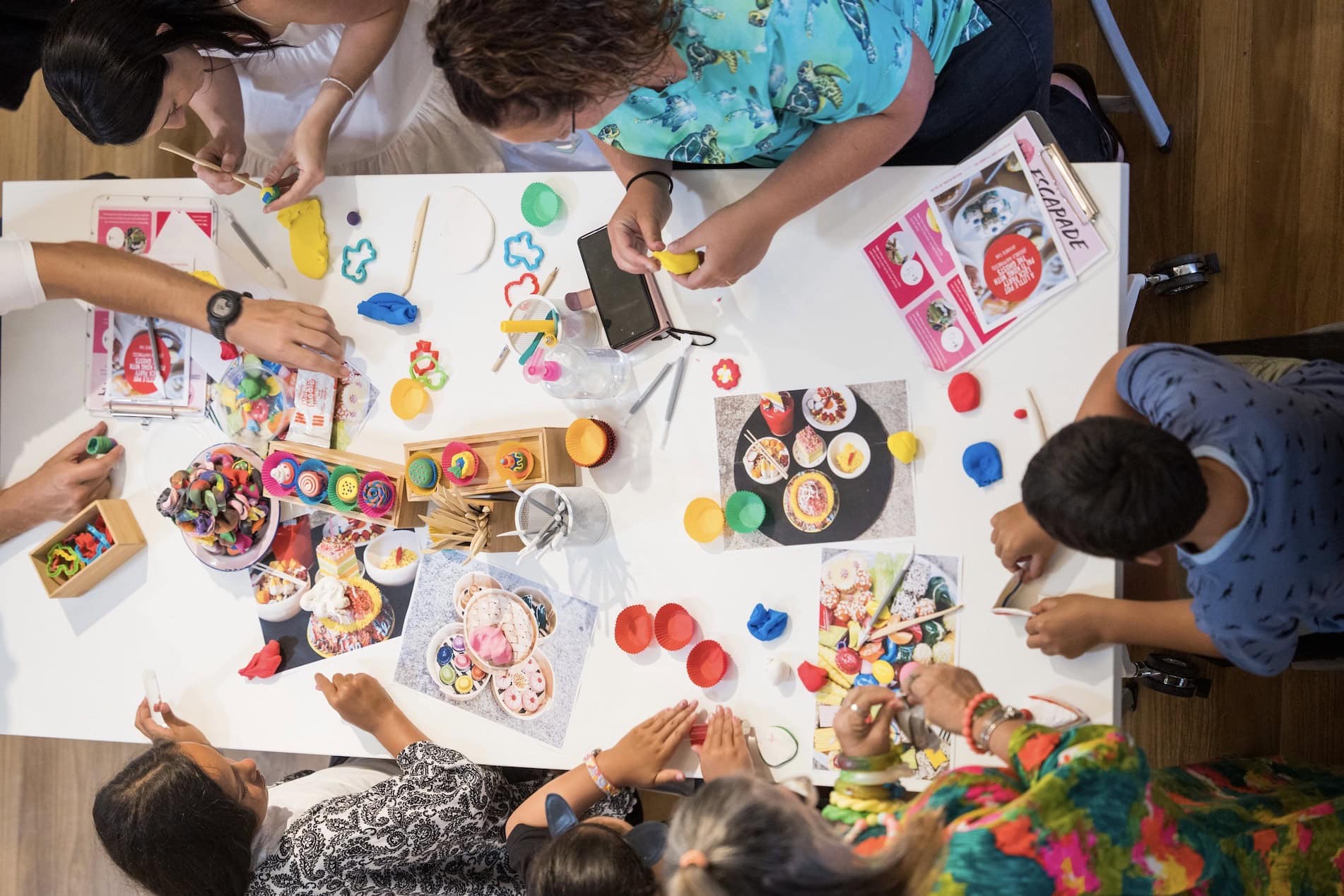 Overhead view of participants making clay food sculptures at creative workshop table Seascapes program Sydney Fish Market Pyrmont