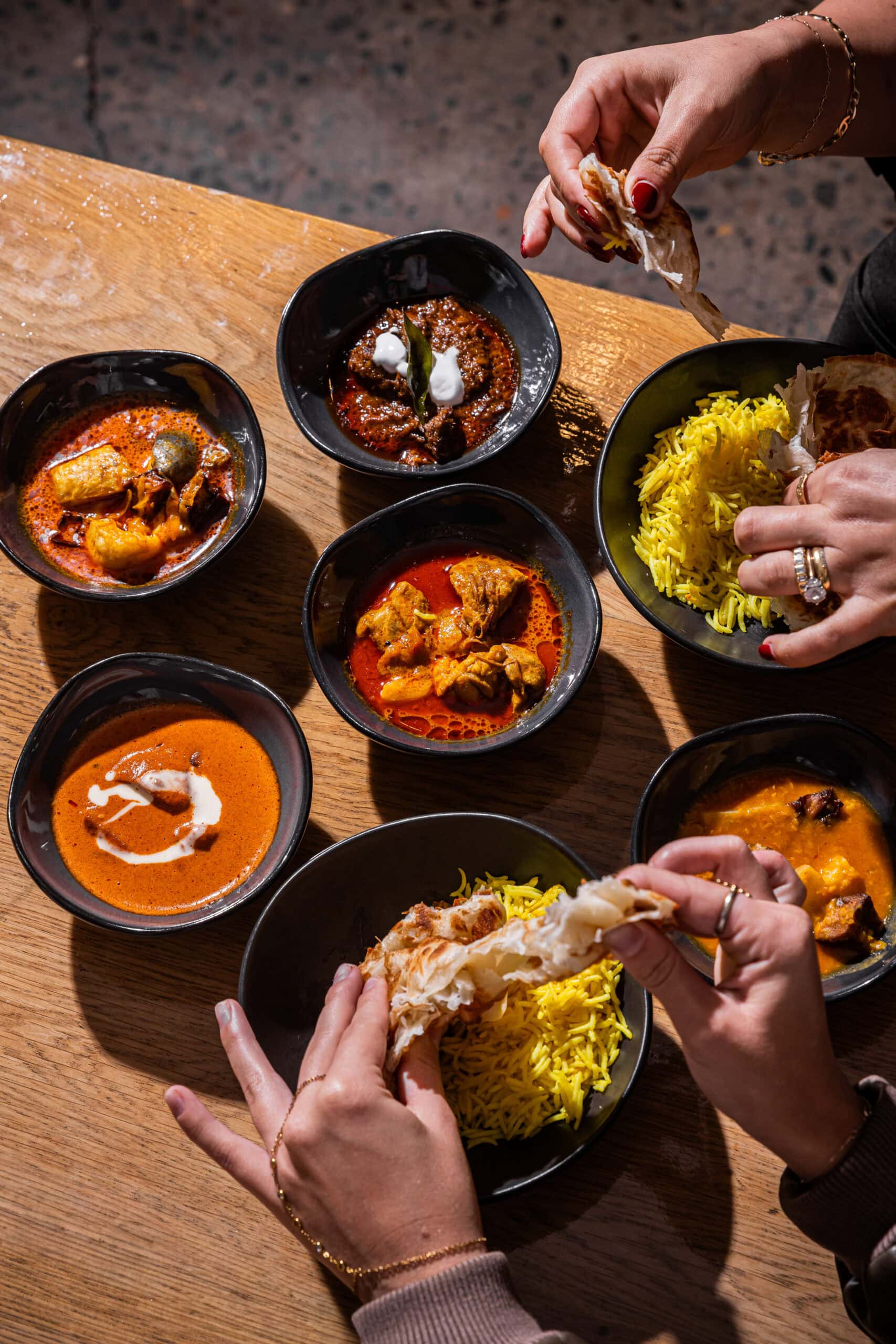 Overhead shot of curry bowls, saffron rice and roti at Kafe Kooks Ultimo Sydney