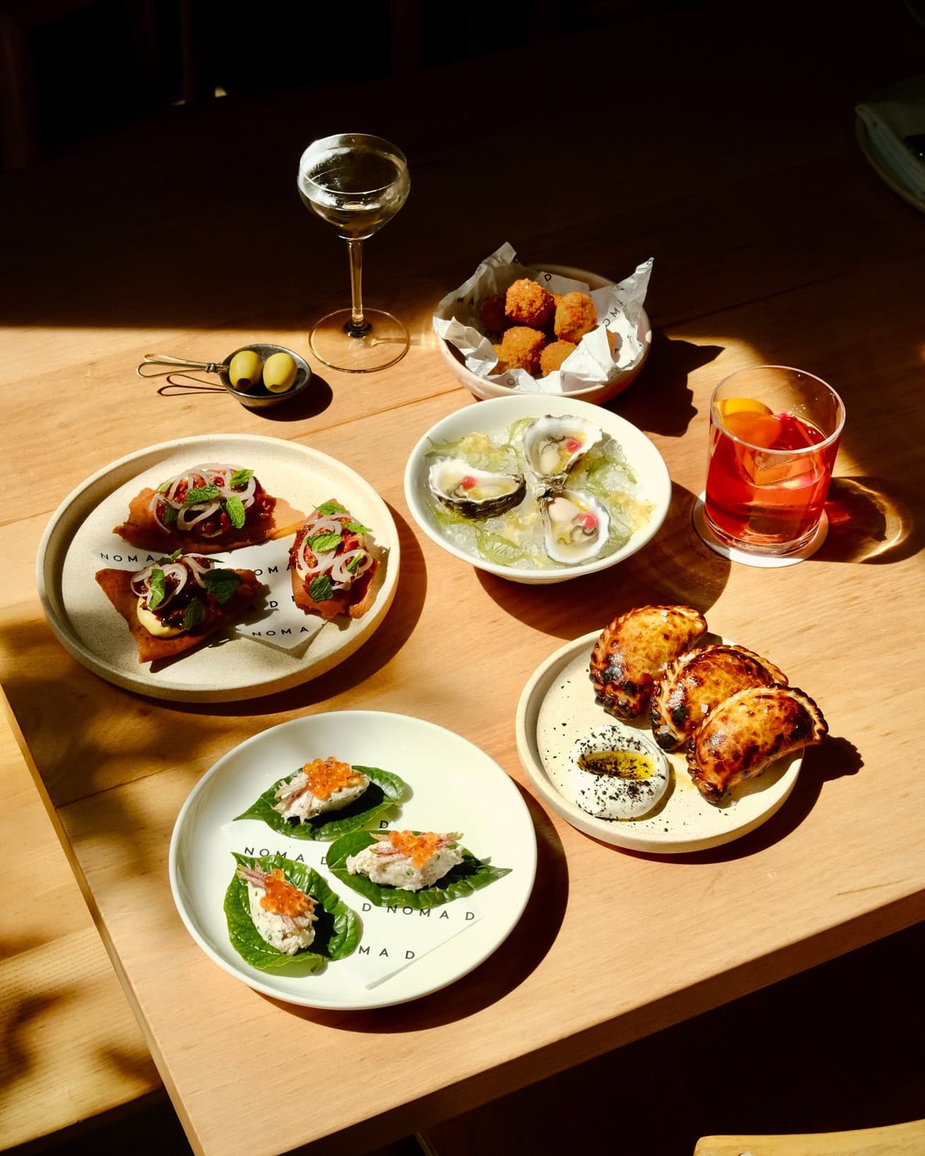 A spread of entrees and snacks for three at Nomad in Sydney.