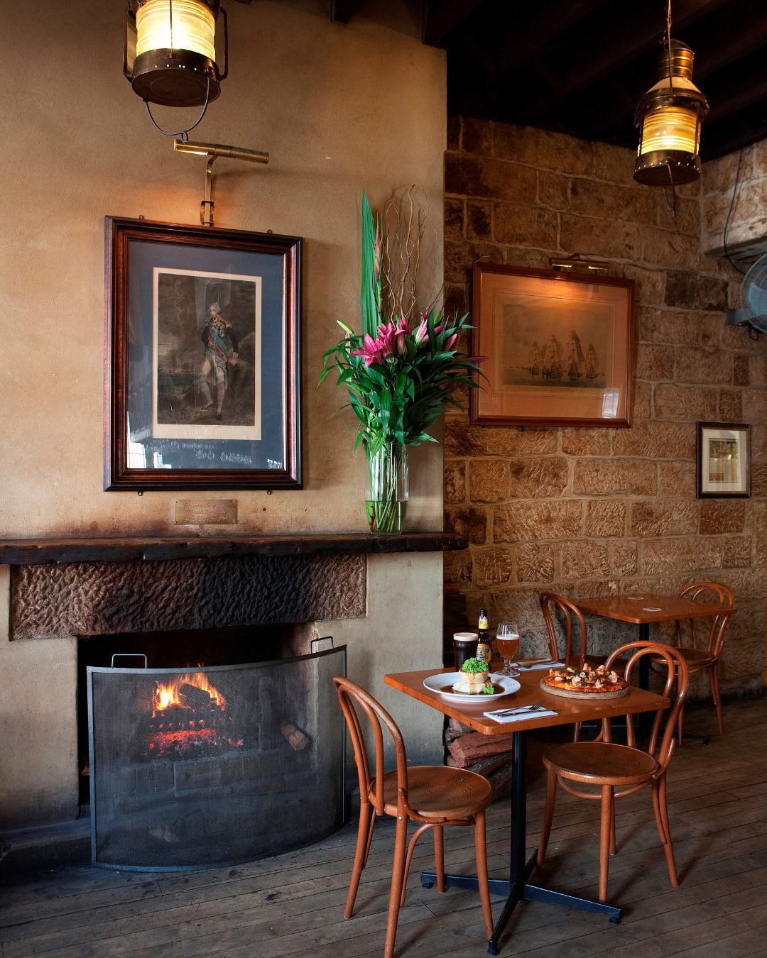 A two person table in front of the fireplace at the historic lord nelson brewery.