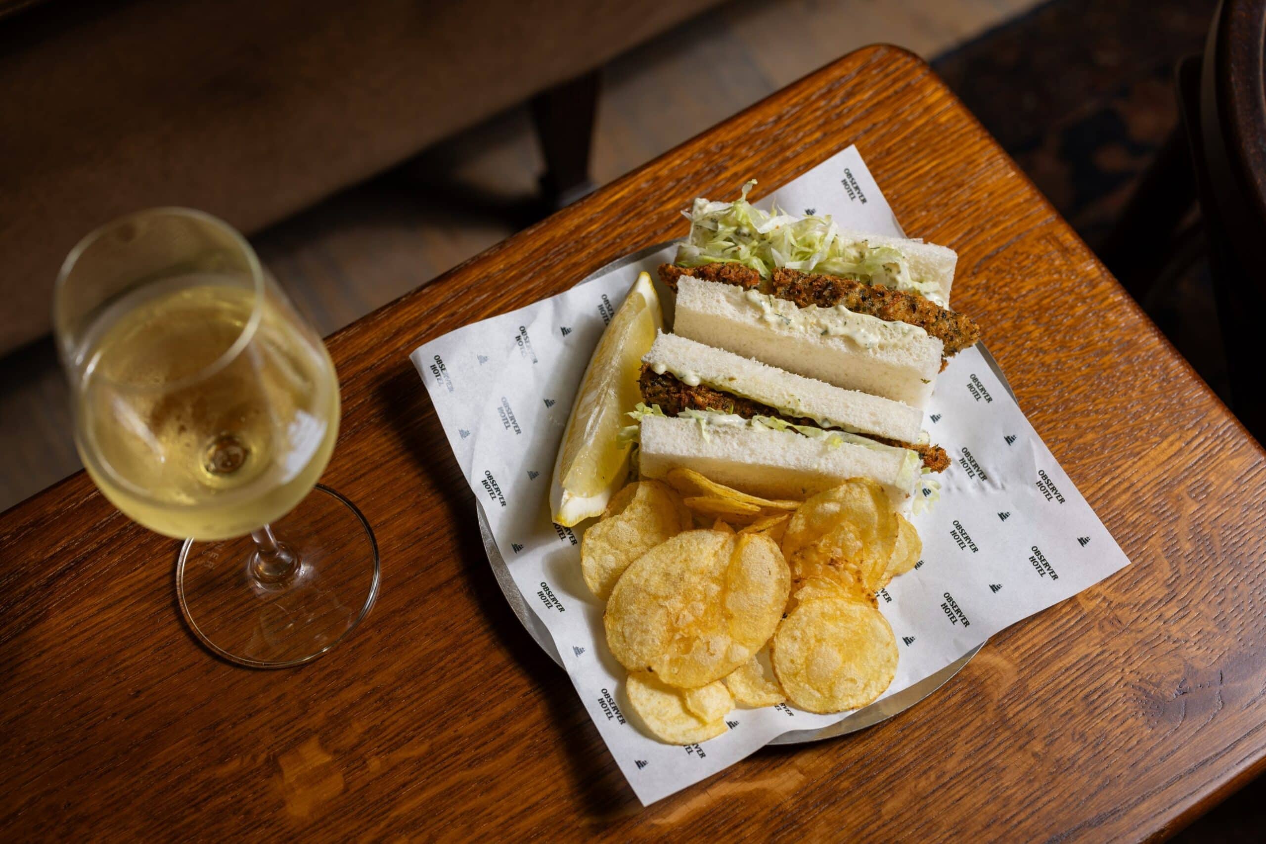 Fish finger sandwich with crisps and white wine at The Observer Hotel The Rocks Sydney