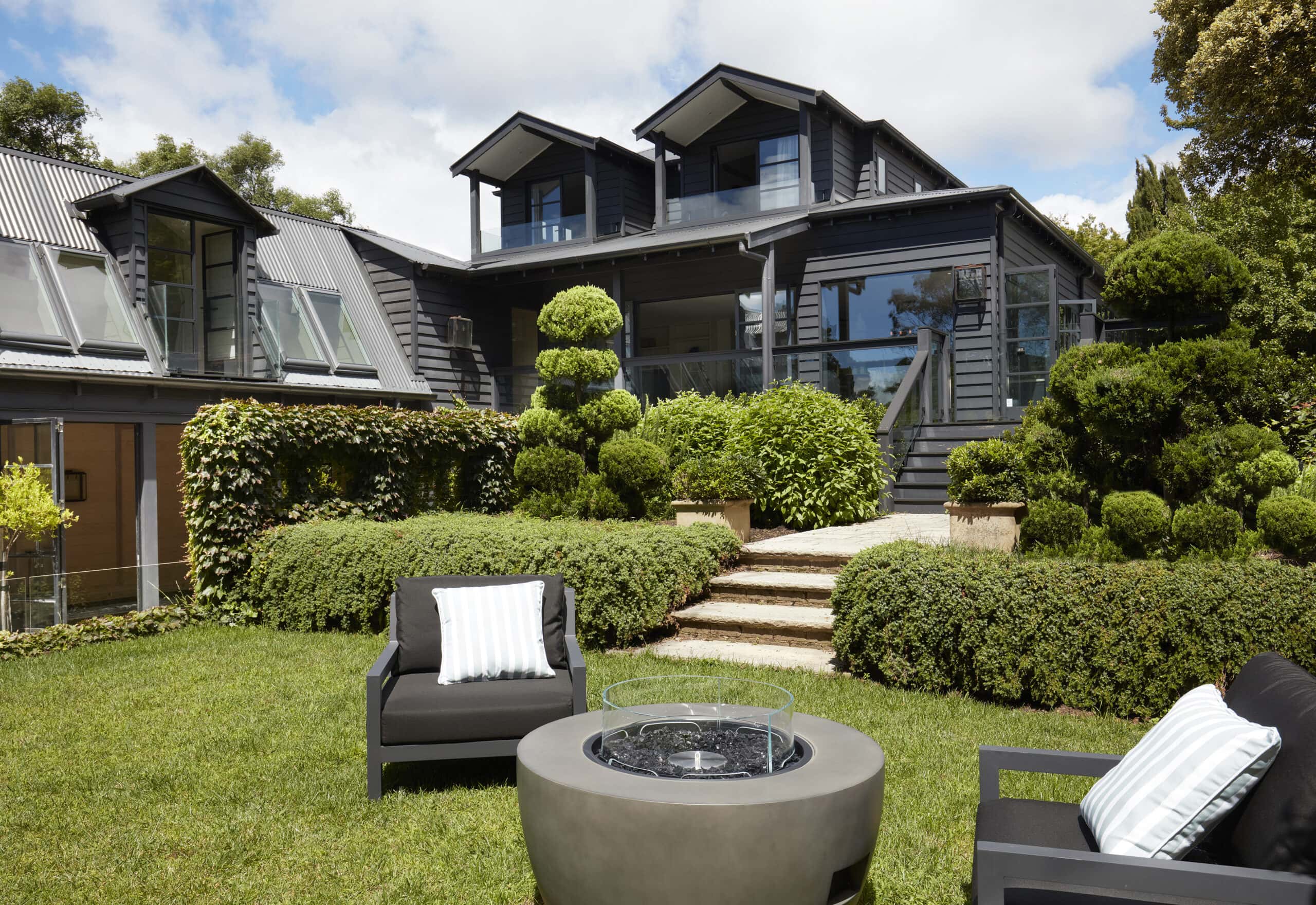 Garden exterior with fire pit outdoor seating manicured topiary and dark timber facade at Sentosa Katoomba Blue Mountains NSW