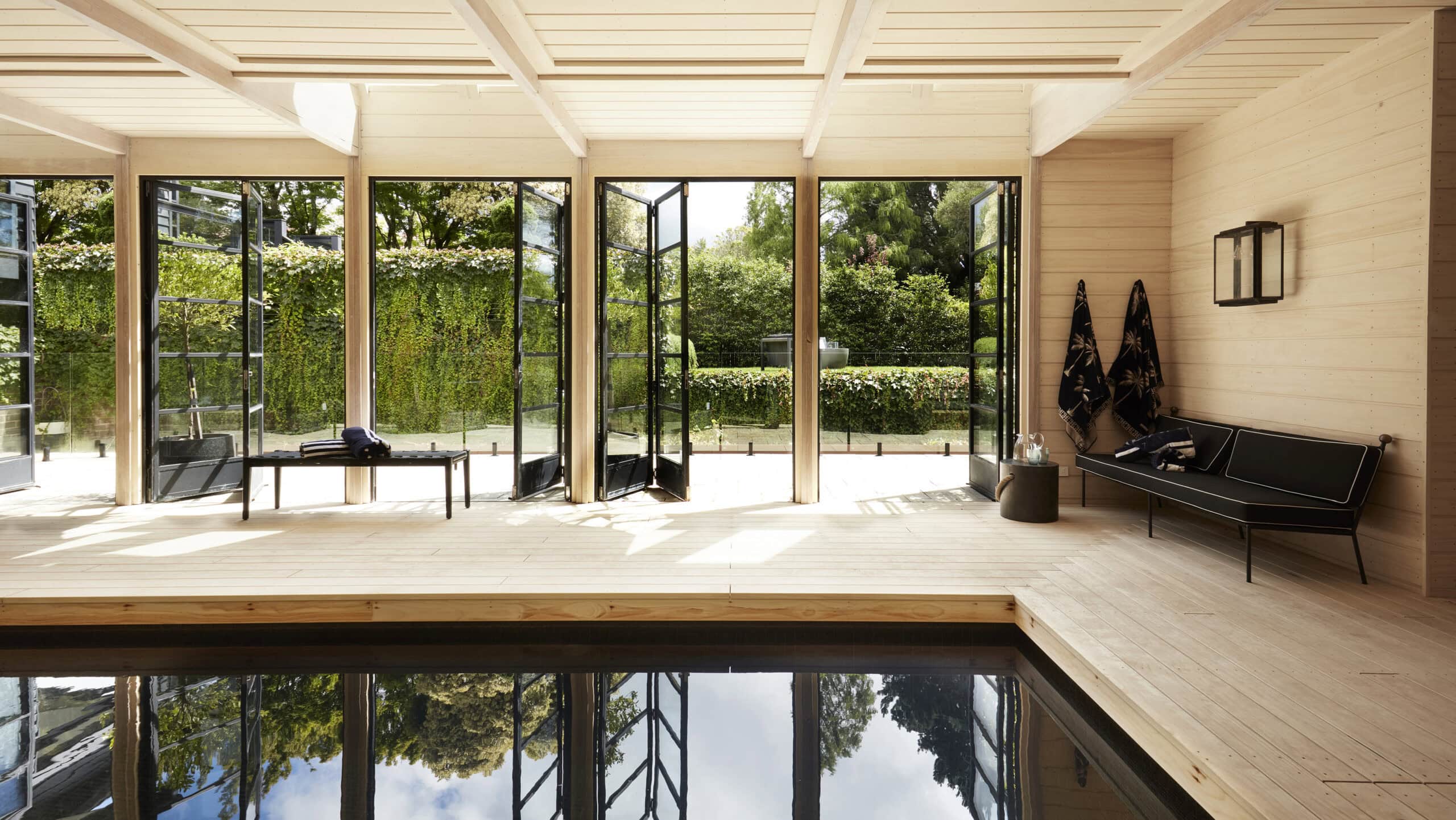 Indoor heated pool with timber deck folding glass doors and garden views at Sentosa Katoomba Blue Mountains NSW