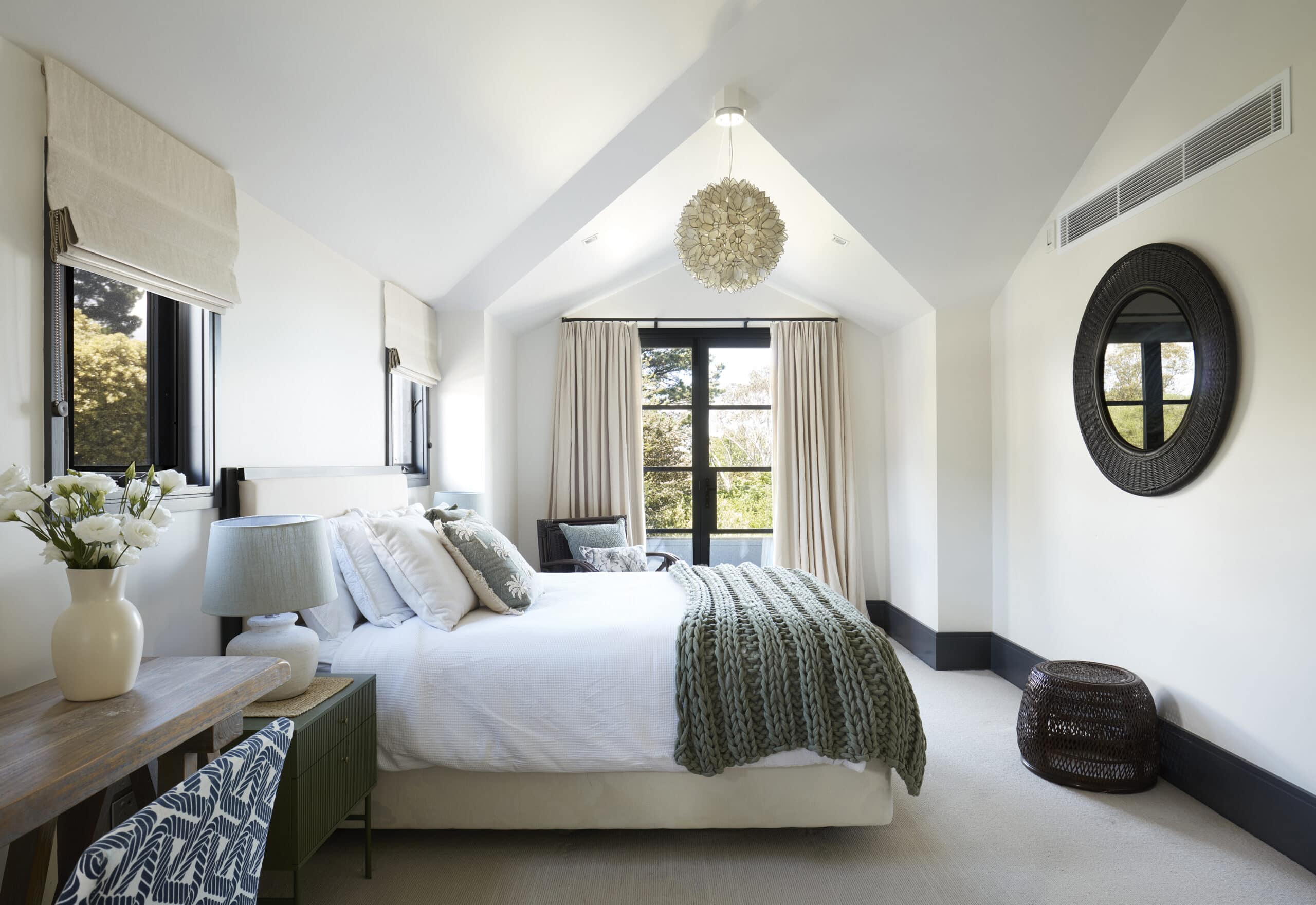 Master bedroom with vaulted cathedral ceiling pendant light chunky knit throw and garden views at Sentosa Katoomba Blue Mountains NSW