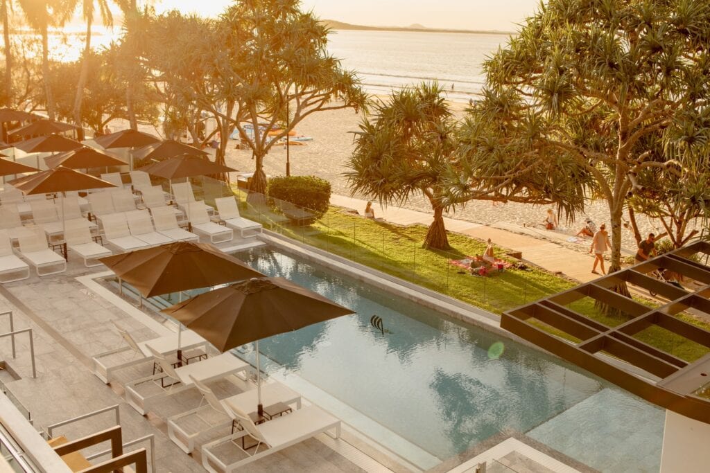 Resort pool surrounded by palm trees at a Noosa accommodation stay.