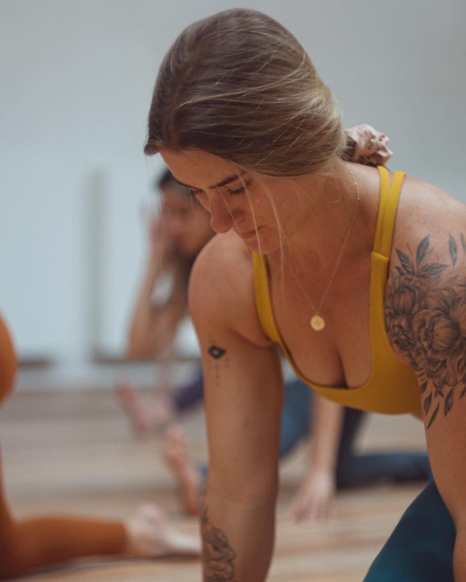 A woman holding a plank-style pose at one hot yoga in kings cross