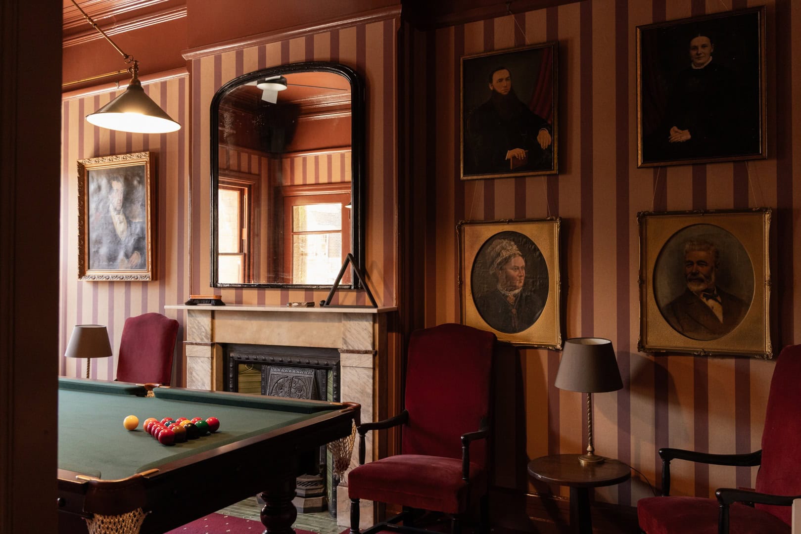 Pool room with billiard table and framed portraits at The Observer Hotel The Rocks Sydney