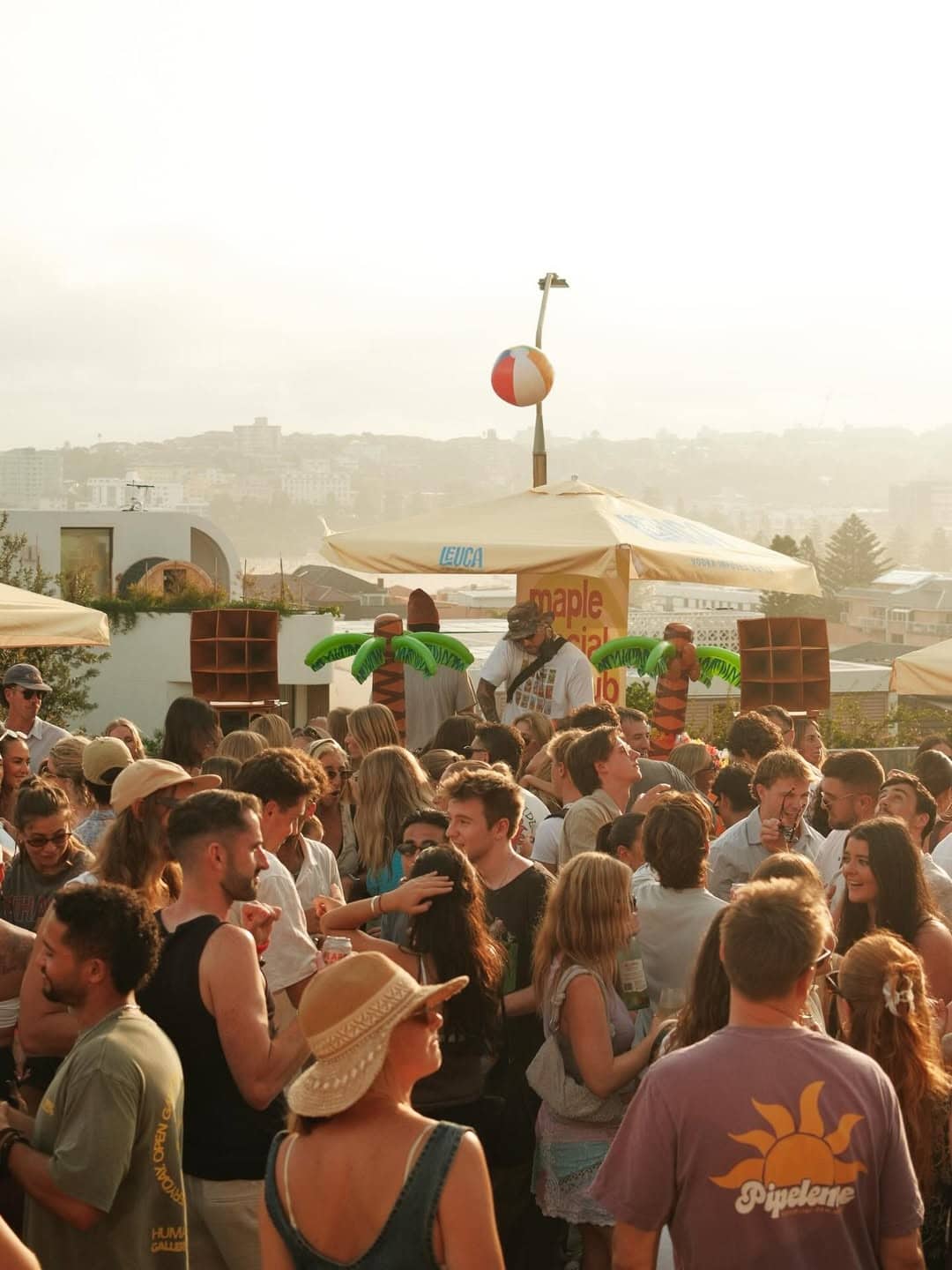 Crowd of people at rooftop sunset event with DJ and harbour views hosted by Maple Social Club Bondi Sydney