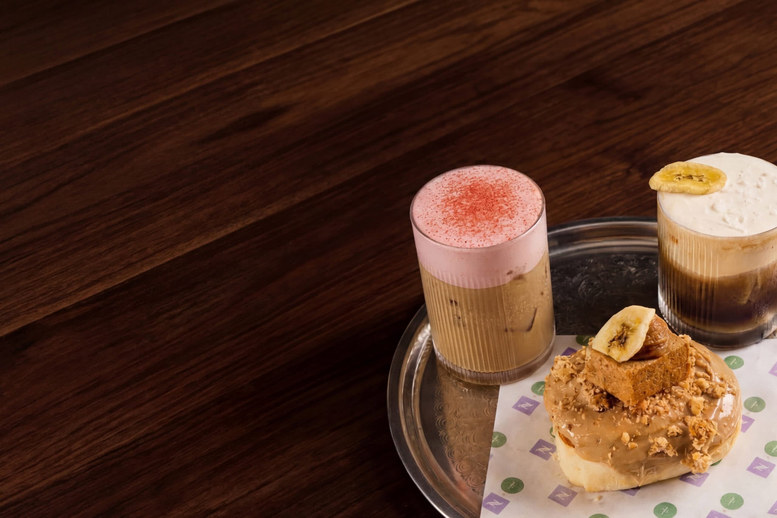 Specialty iced coffees and banana bread scroll on silver tray at Nespresso Lab Pitt Street Sydney CBD in collaboration with Sundays Bondi