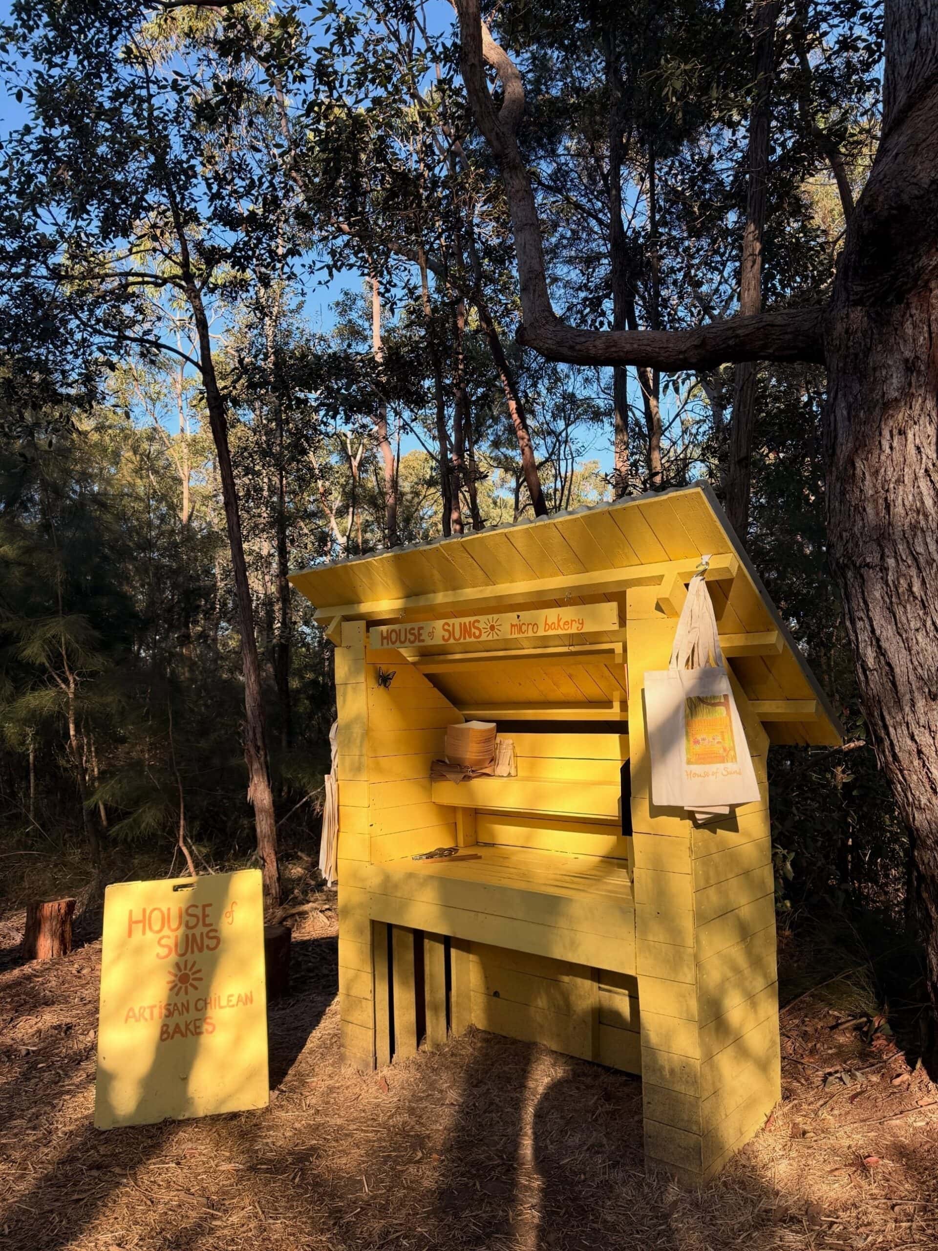 Yellow roadside stand of House of Suns micro bakery in Blue Mountains bushland