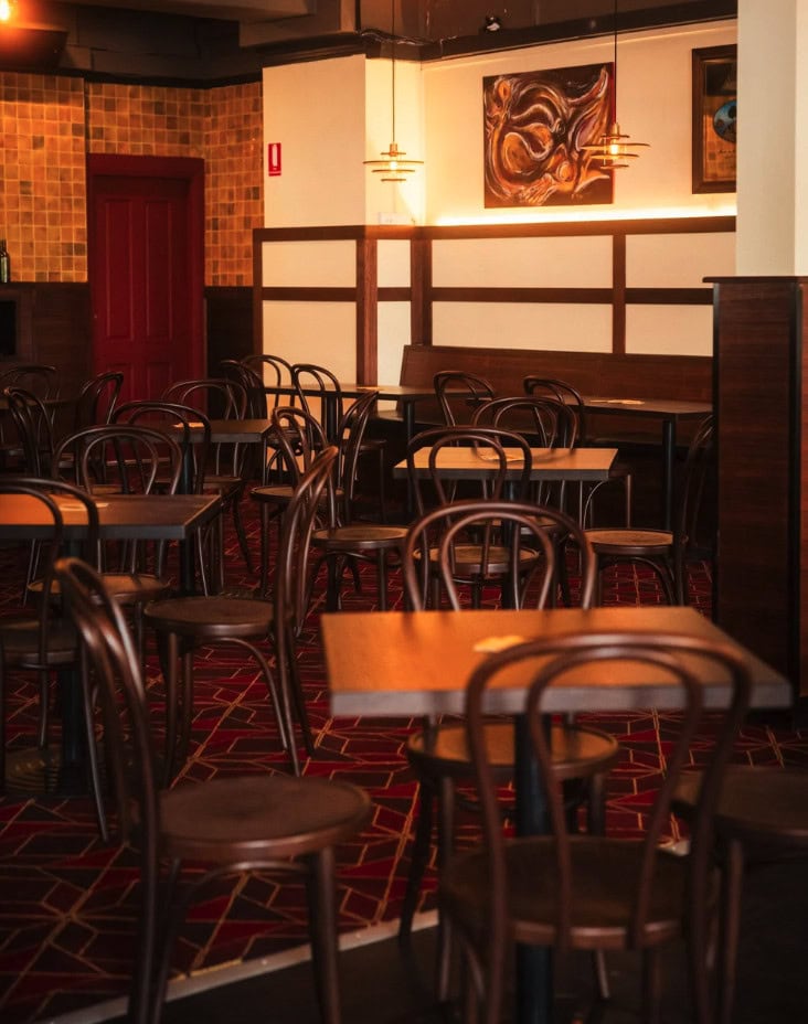 Bar interior with timber tables bentwood chairs patterned carpet and artwork Bat and Ball Hotel Redfern Sydney