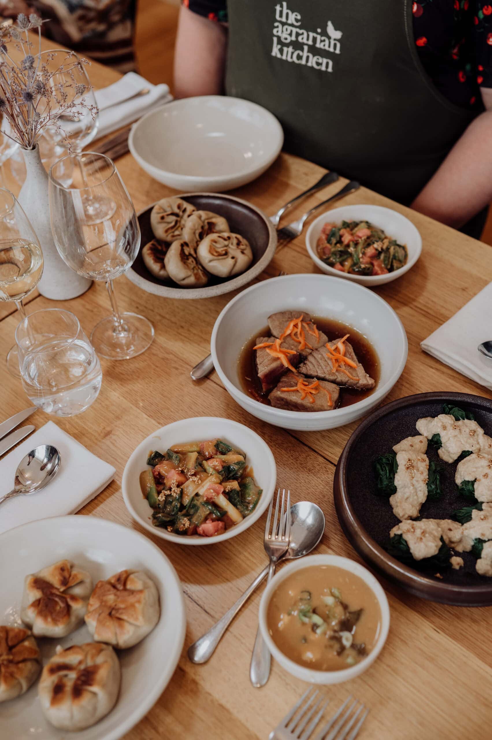Japanese-inspired dishes served at The Agrarian Kitchen cooking class, with dumplings, vegetables and bowls on the table.