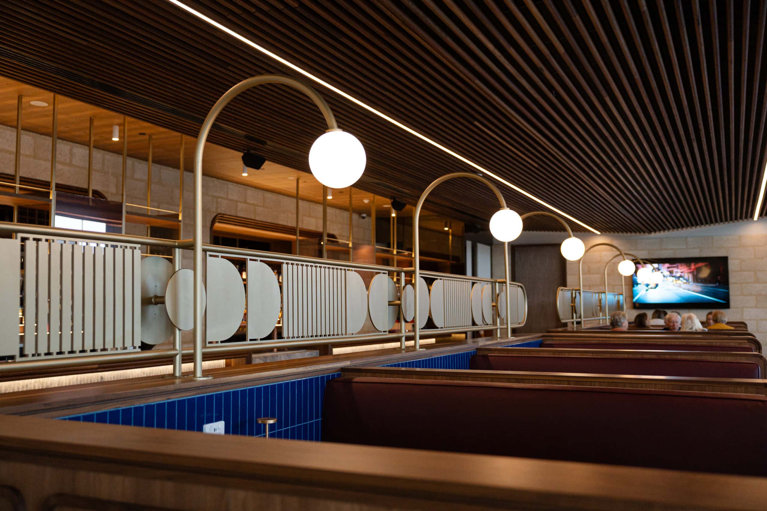 Sunken booth seating with globe pendant lights and brass detailing in the Lobby Bar at Hotel Panorama.