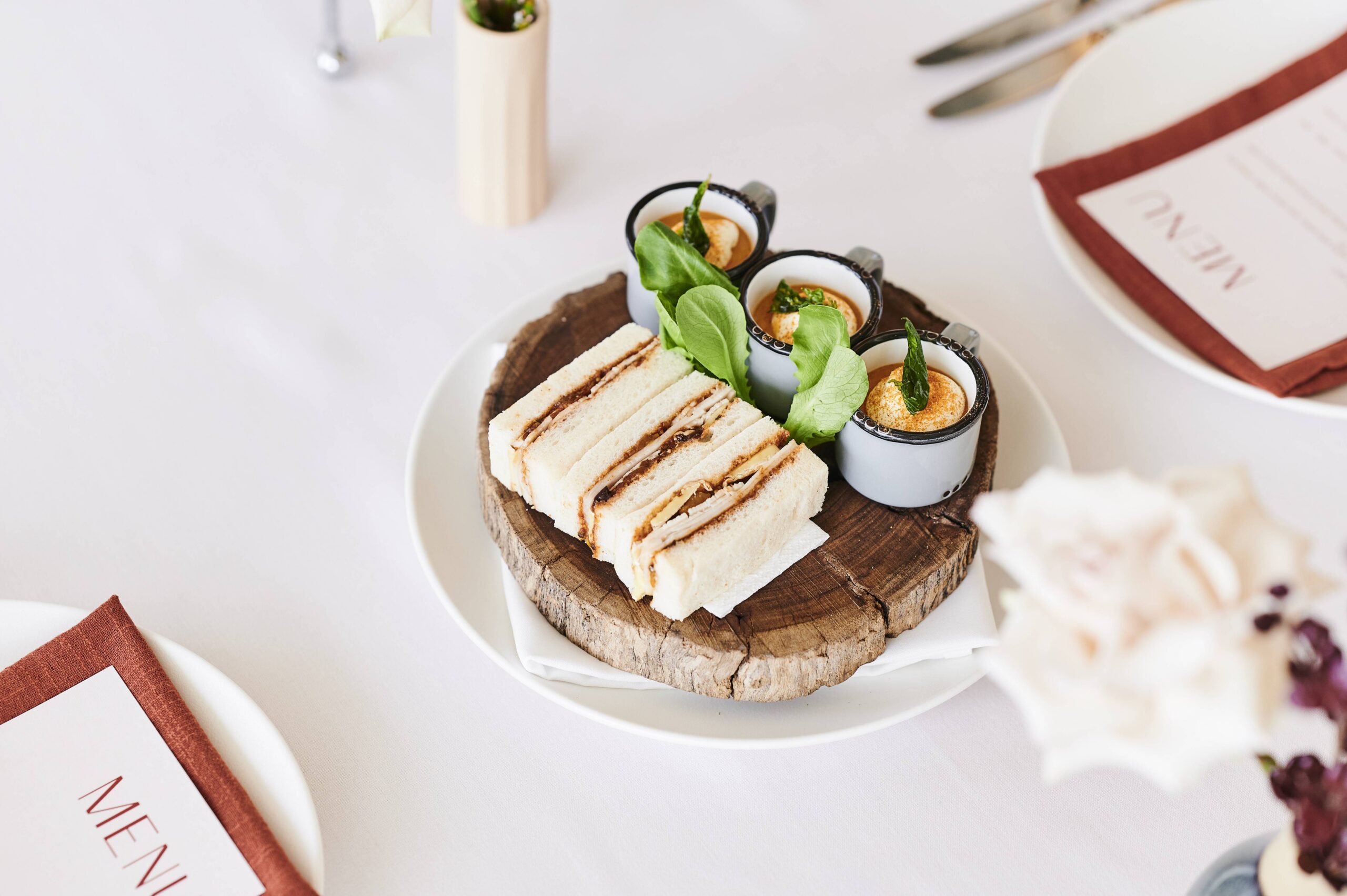 Afternoon tea sandwiches and canapés on rustic wood board Queen's Terrace Cafe Parliament House Canberra