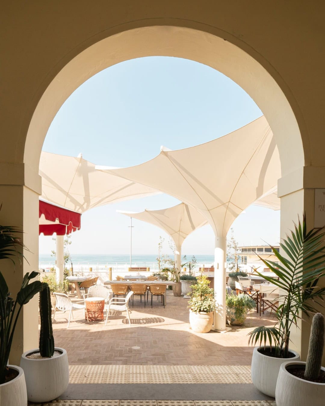 An arch leading out to the alfresco, beach front dining area at beach bar promenade.