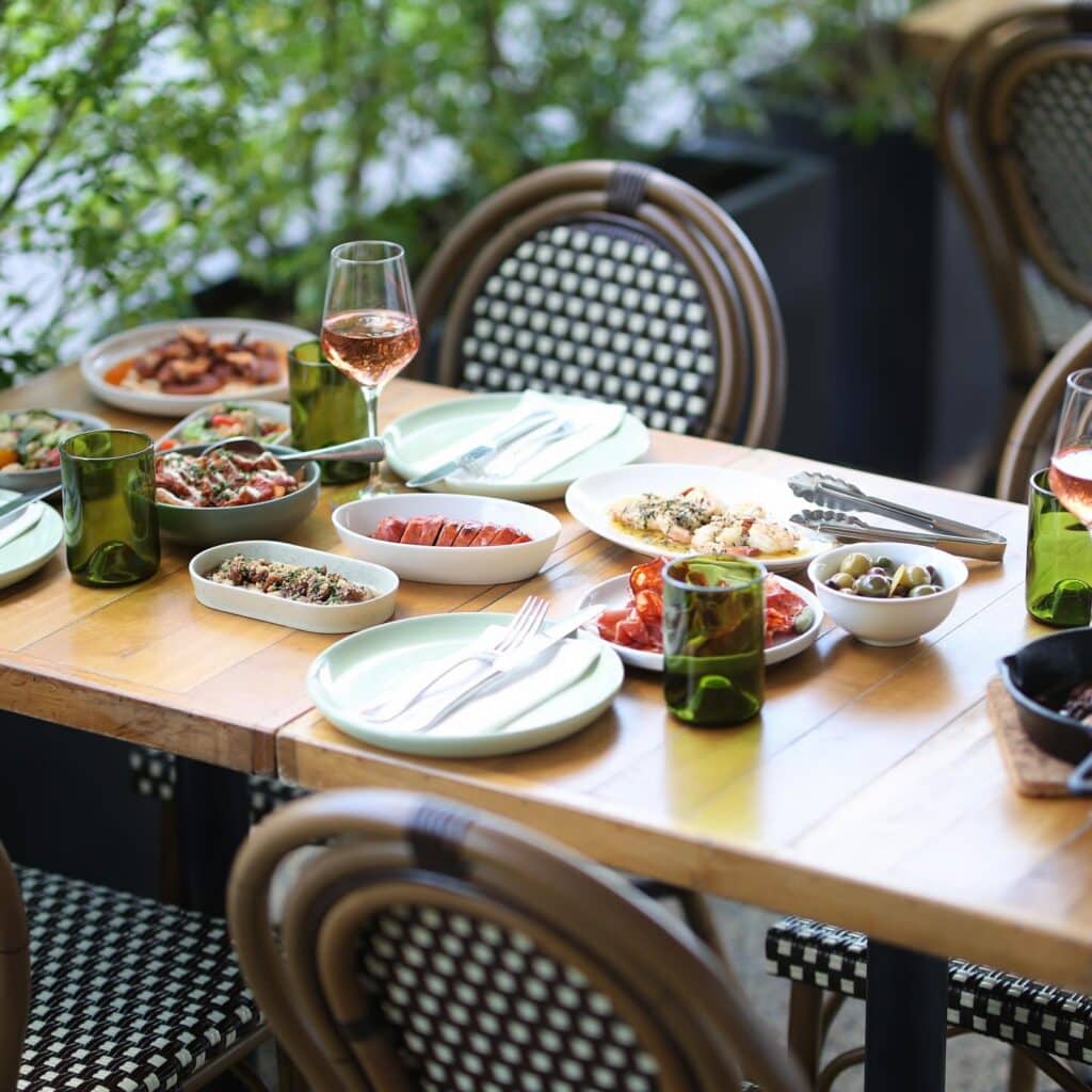 An alfresco dining table stacked with food at Botellon in Brisbane.