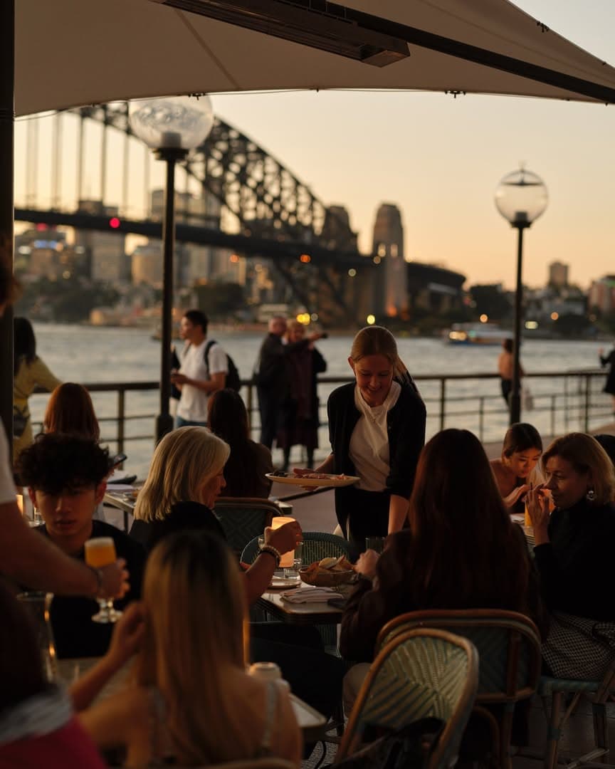 A bustling alfresco dining area at Whalebridge, overlooking the Sydney Harbour Bridge