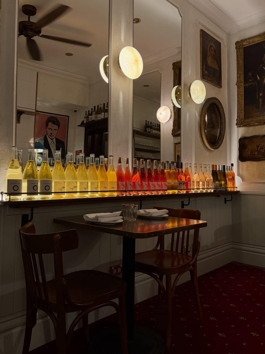 Backlit natural wine bottle display with bentwood chairs red carpet and oil paintings at Cir.1890 by Circa Parramatta Sydney
