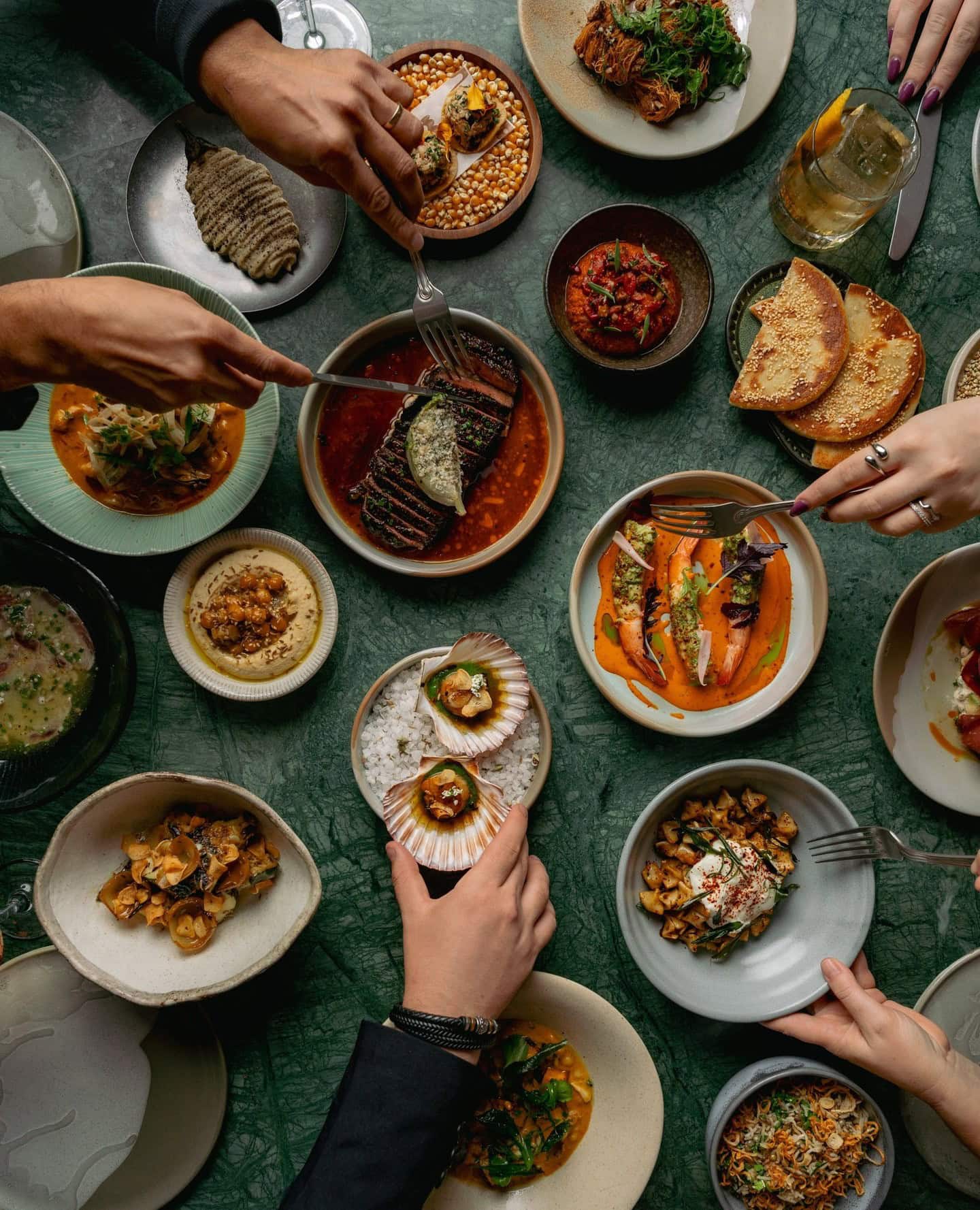 A spread of dishes with multiple people tucking in at layla in Brisbane.
