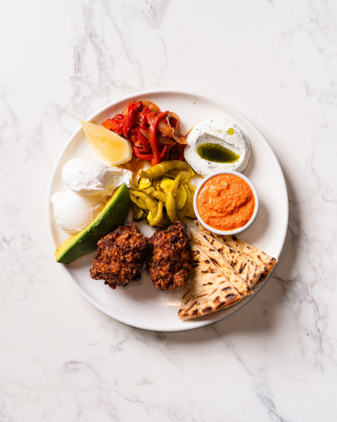 A brunch plate full of pickles, eggs and bread at Next Door in Cronulla.