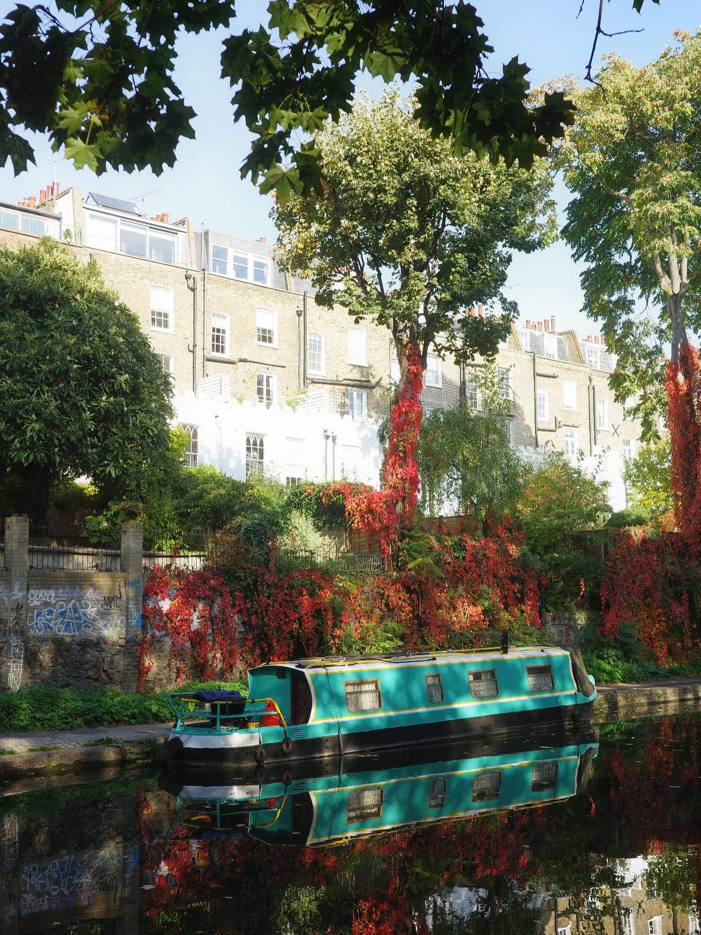 Autumn on Regents Canal, featuring red leaves and a canal boat.