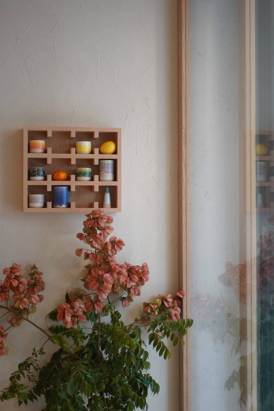 Small wooden display shelf with colourful ceramic cups at Noom Rosebery Sydney