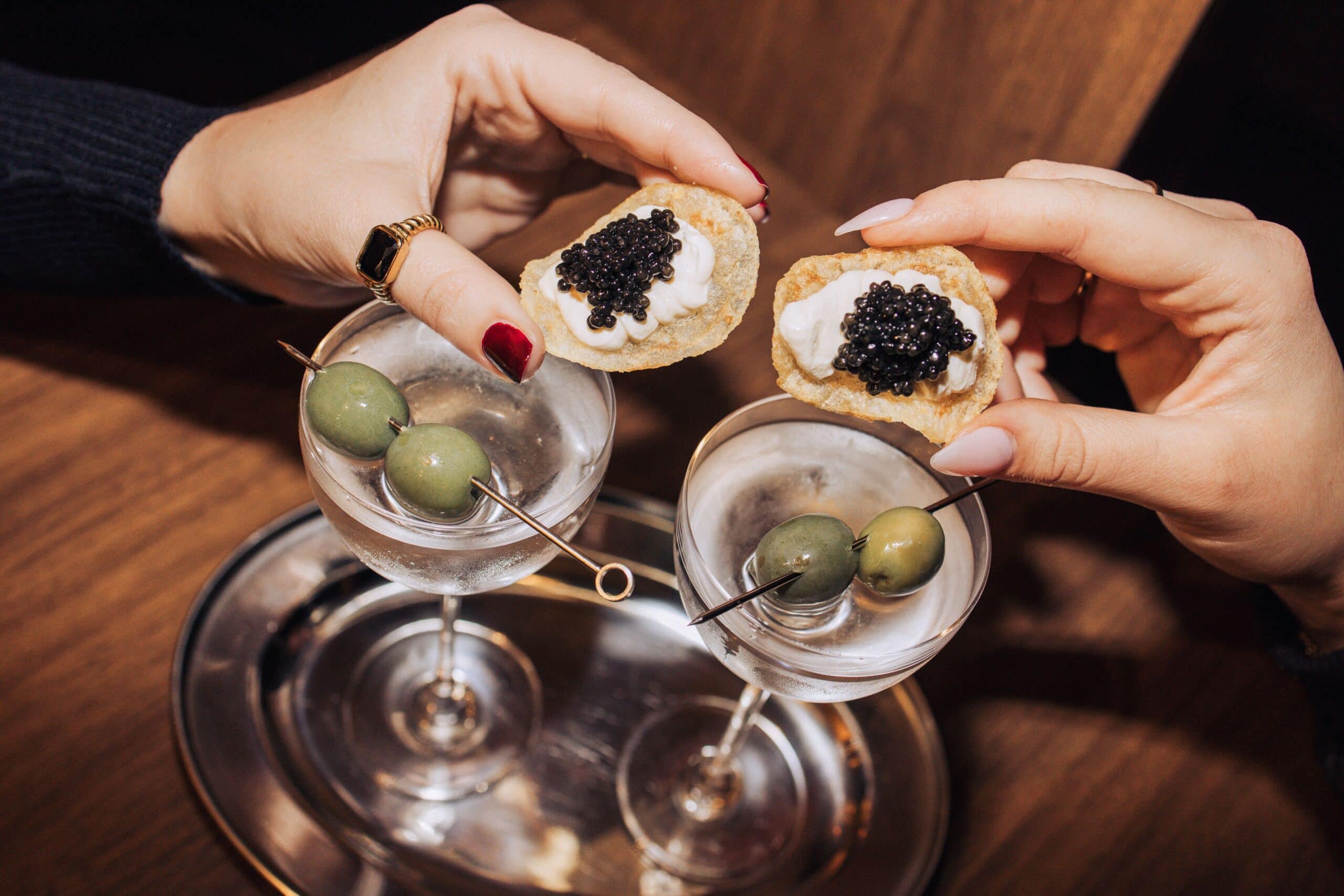 Classic dirty martinis with olive skewers and caviar blini crisps on silver tray at Duke's After Hours Paddington Sydney