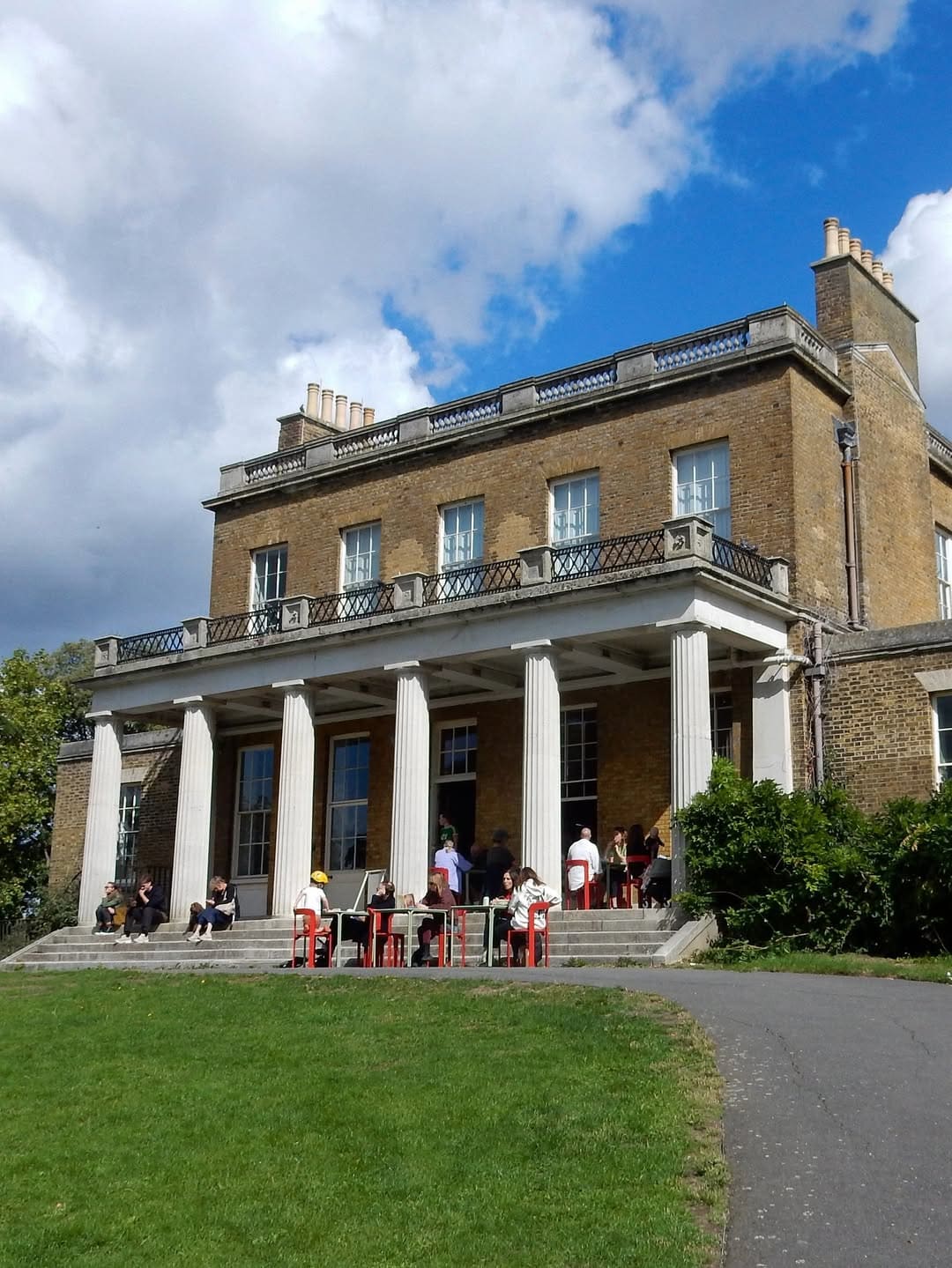 People enjoying coffee on the balcony at the 18th century Clissold House in Clissold Park, Stoke Newington.