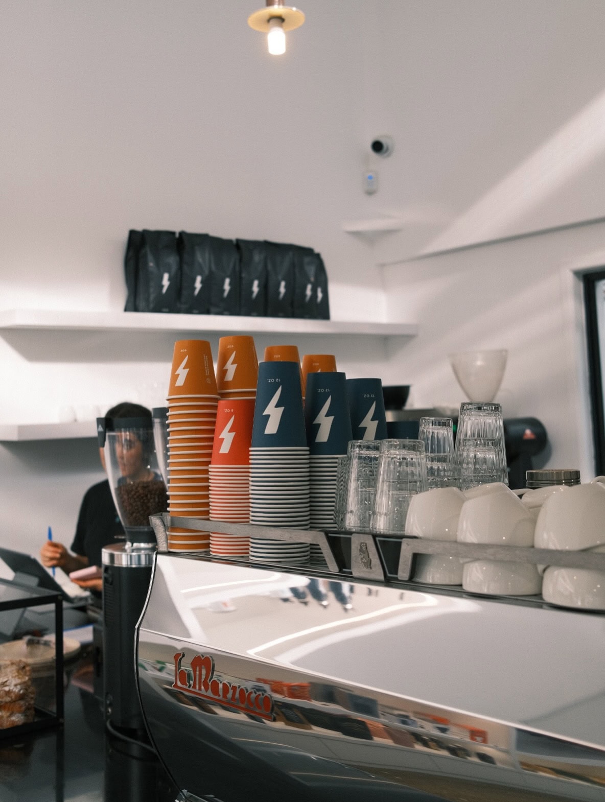 A silver coffee machine topped with takeaway cups at Fonzie Abbott in Brisbane.