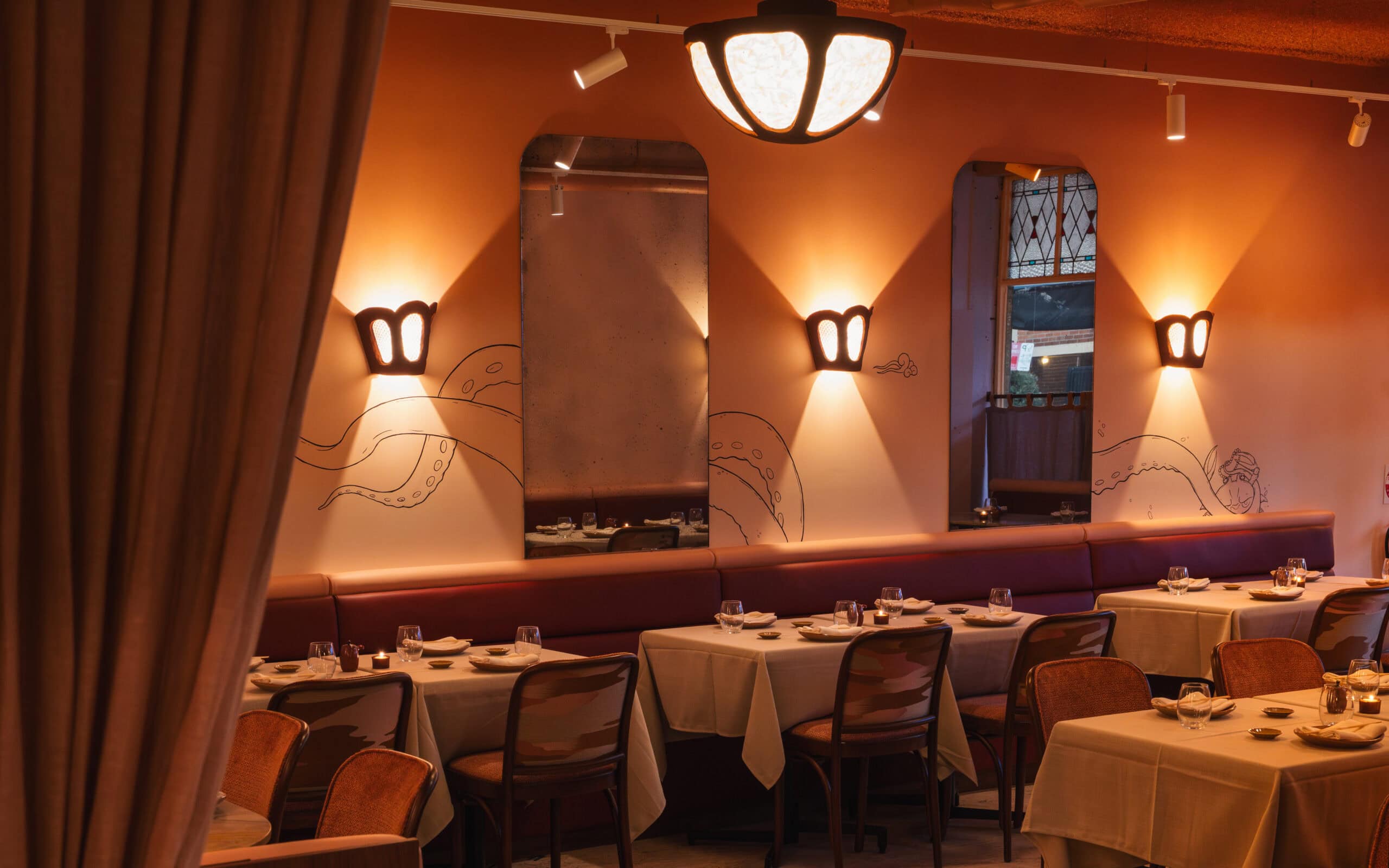 Cozy restaurant dining area featuring warm ambient lighting, modern decor, and neatly arranged table.