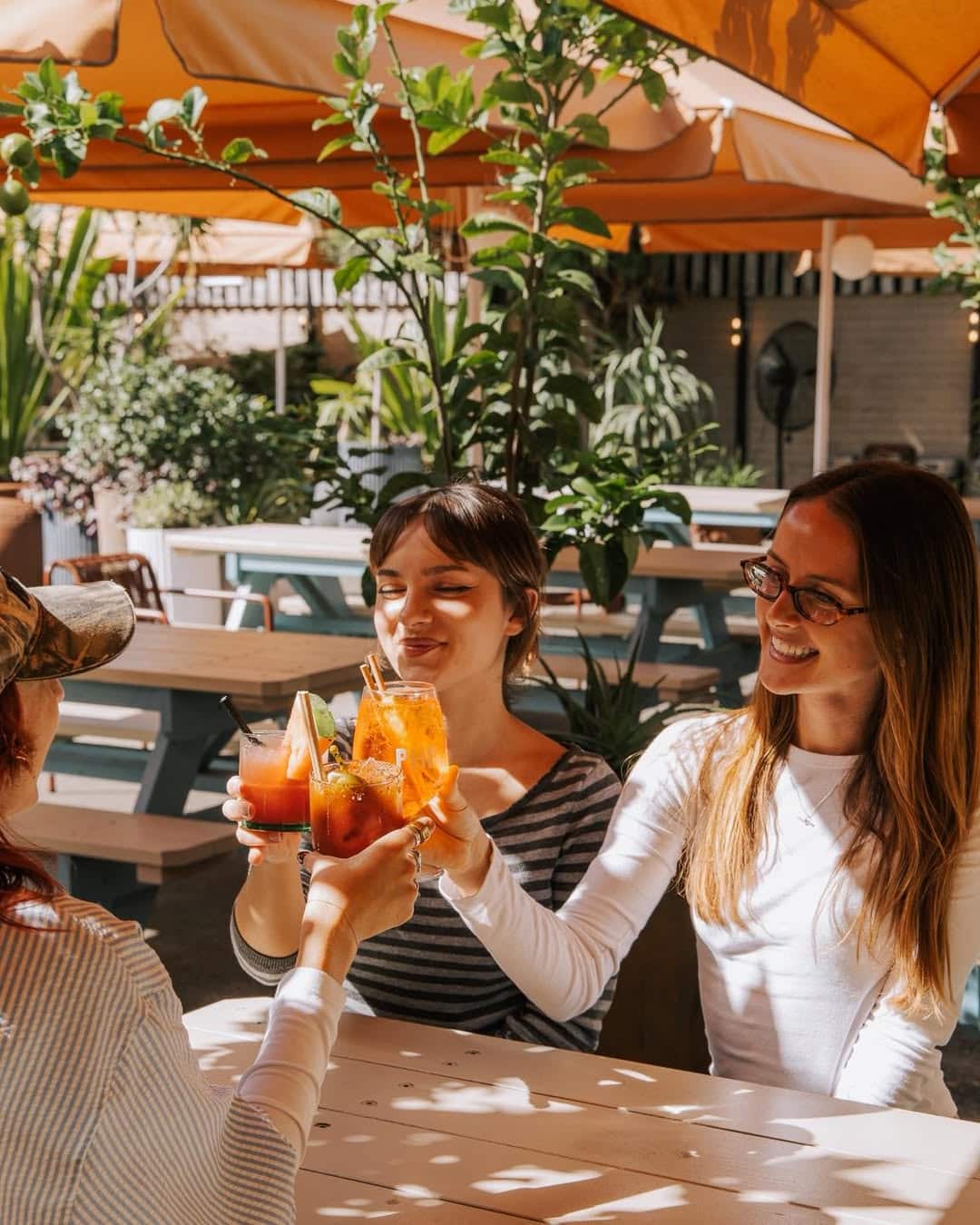 A group of ladies enjoying Aperol spritz in the sunny beer garden at Public House Petersham.