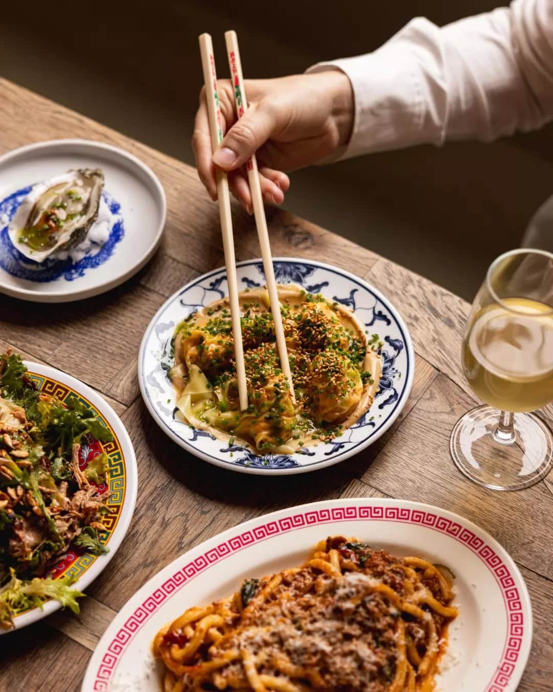 Someone using chopsticks to pick up dumplings at Ling Ling's in Godet, Islington.