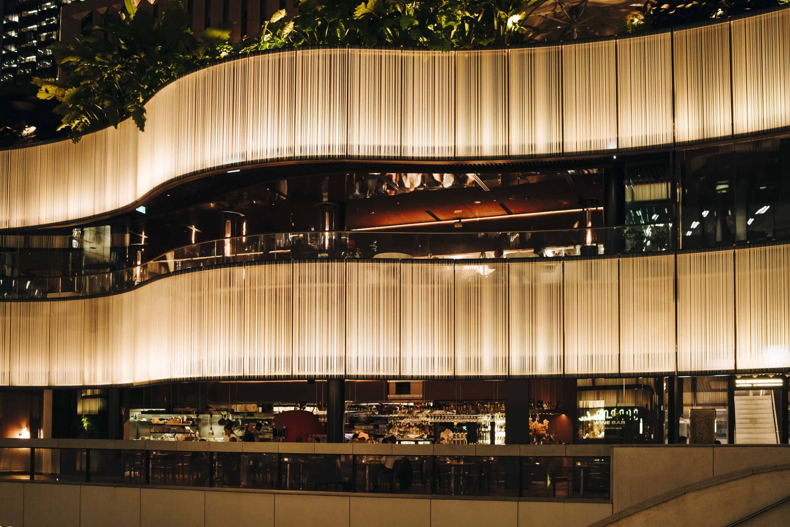 Multi-level exterior facade with fringe curtain detail at night at The International Sydney
