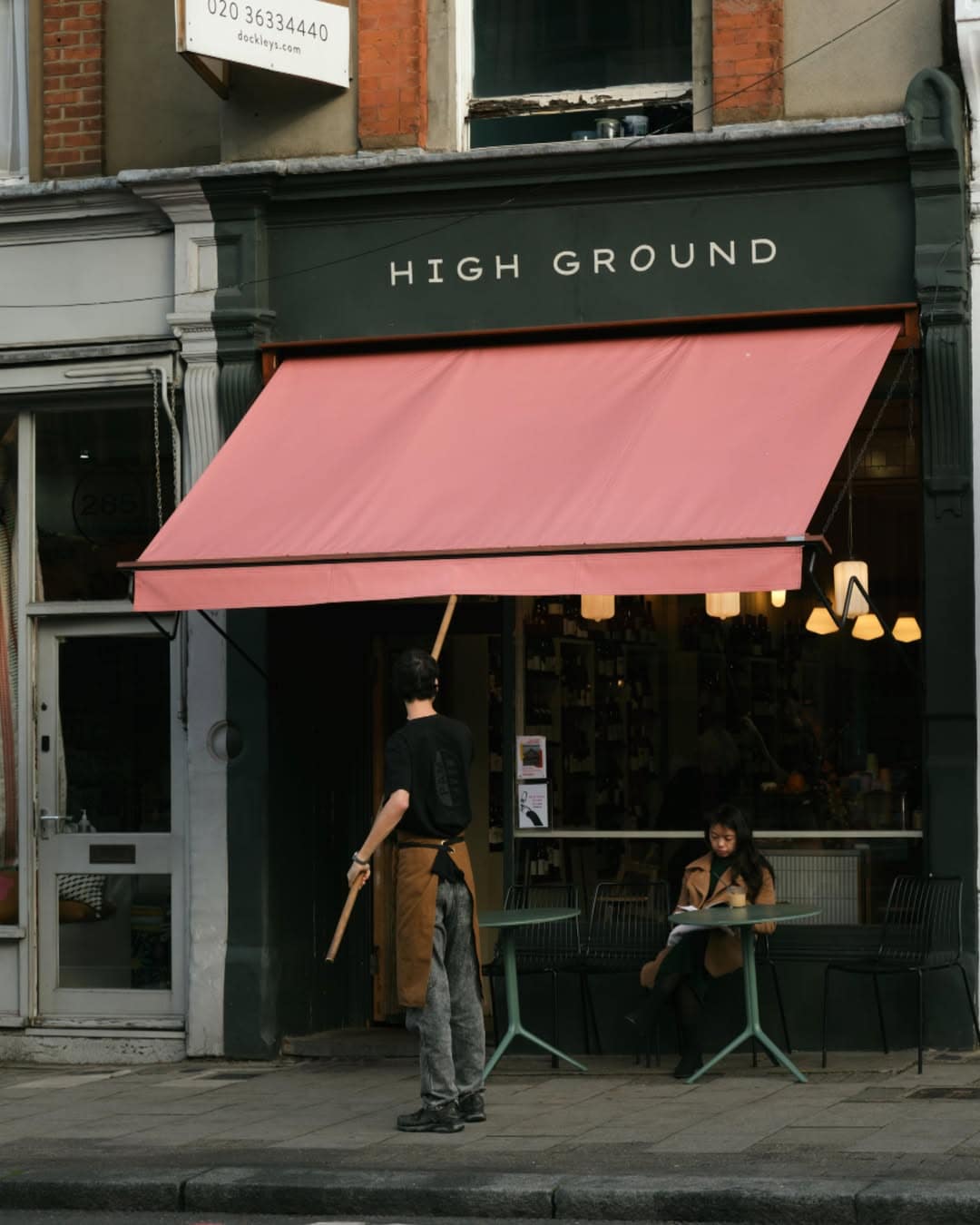The exterior of High Ground coffee on Upper Street, featuring a black facade and red awning.