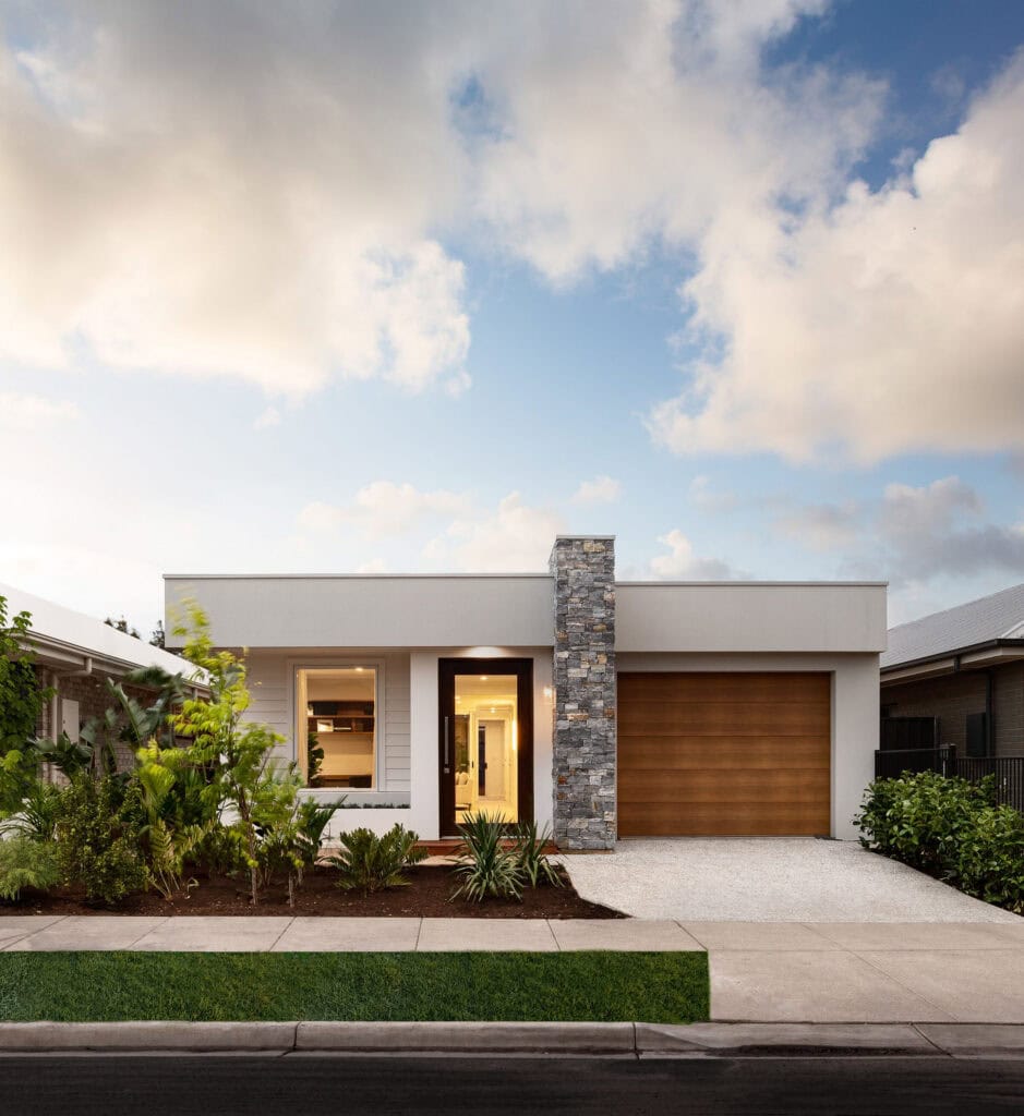 A modern display home by Weeks Homes at Playford Alive, featuring a rendered white facade, stone feature column, timber garage door and native garden landscaping.