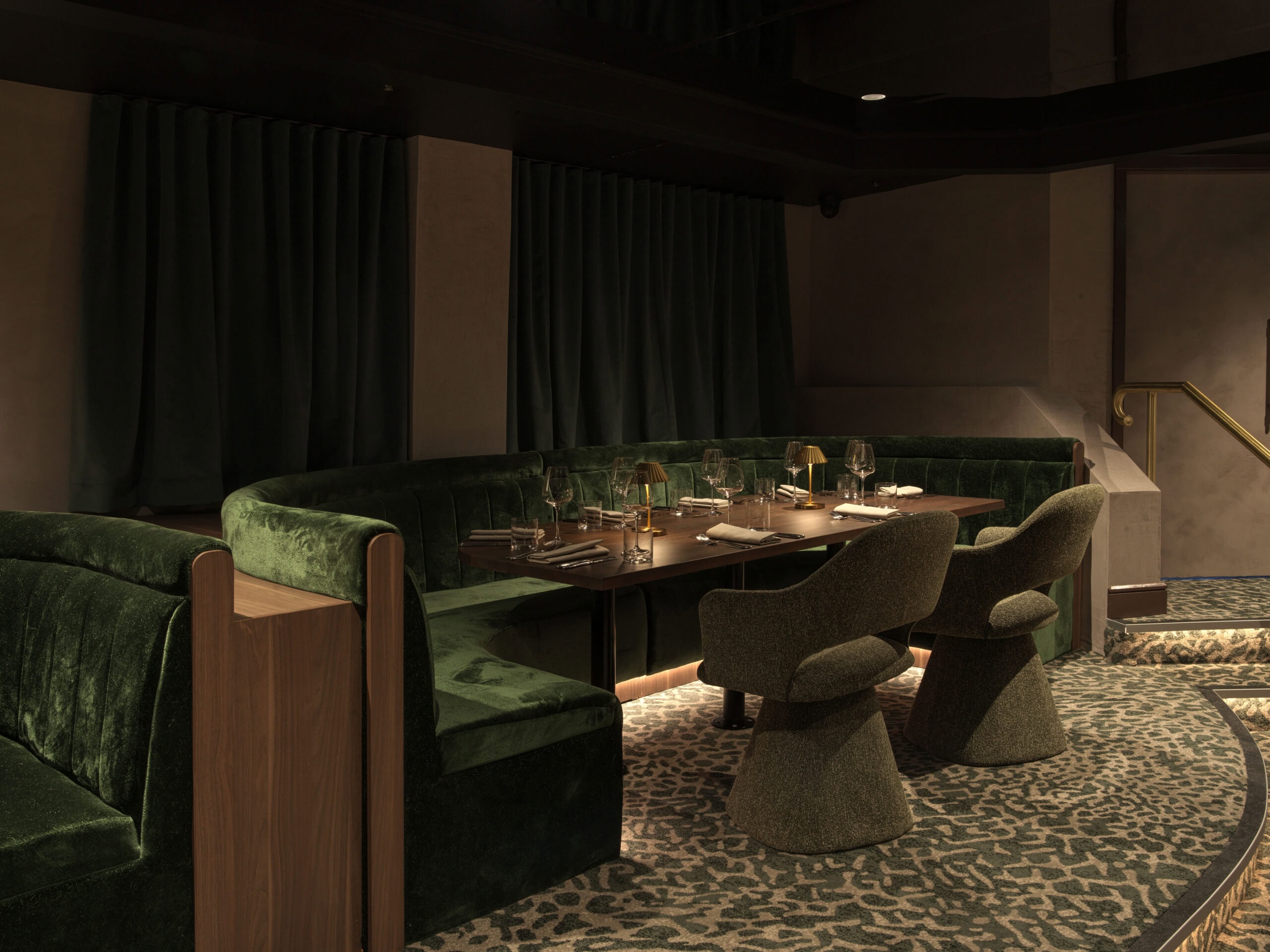 Moody underground dining room with green velvet banquette booths leopard print carpet and candlelit tables at The Hideaway Bondi Junction Sydney