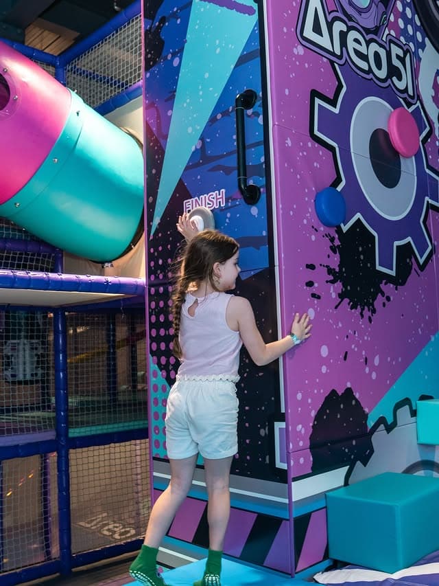 A little girl playing at the purple and blue indoor play centre area 51.