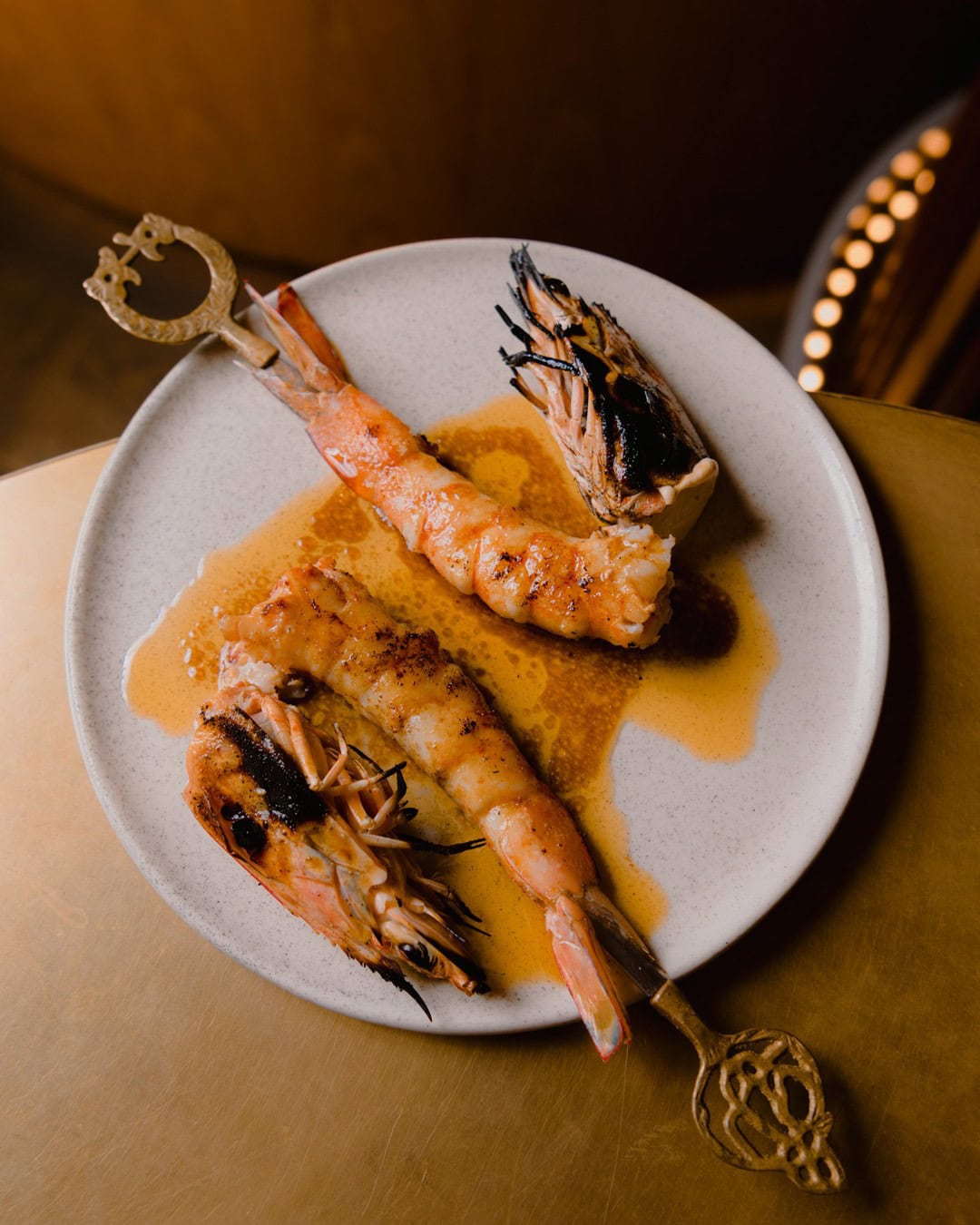 An intricately plated King prawn dish, featuring prawns on elaborate skewers, at Aalia in Sydney's CBD.