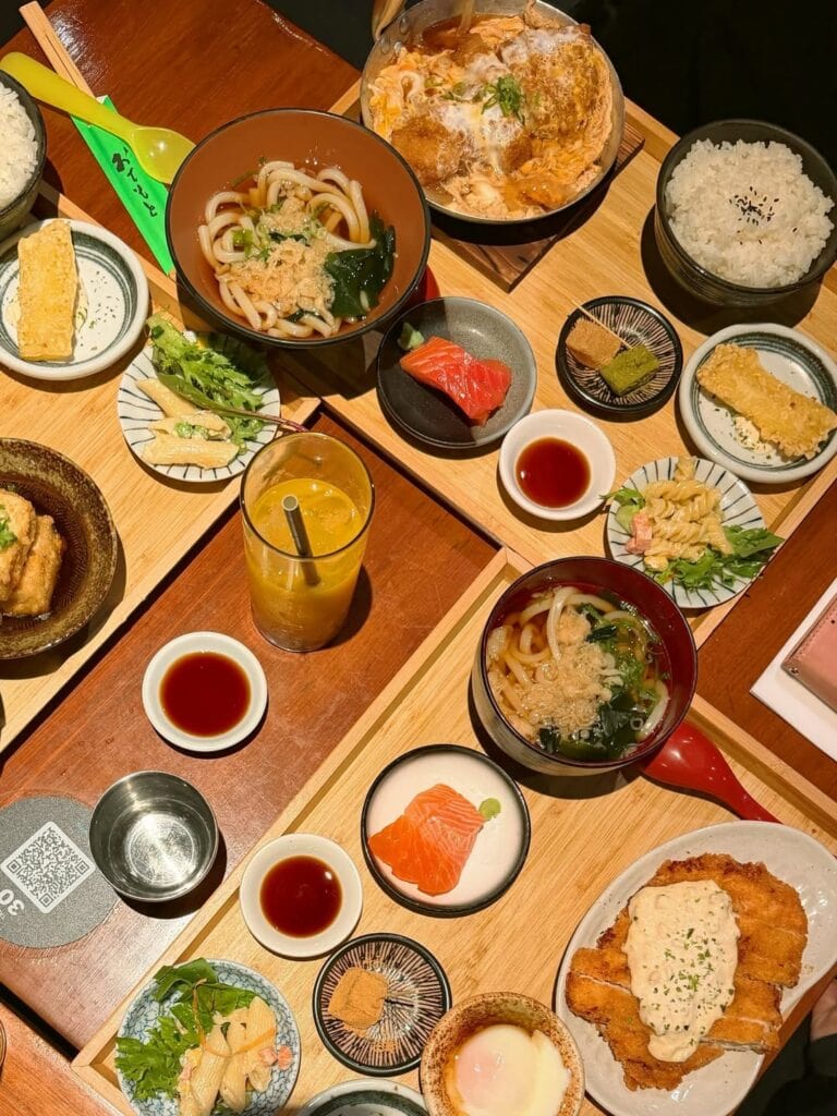 Kura Kura overhead table spread with udon soup salmon sashimi chicken katsu and donburi Haymarket Sydney