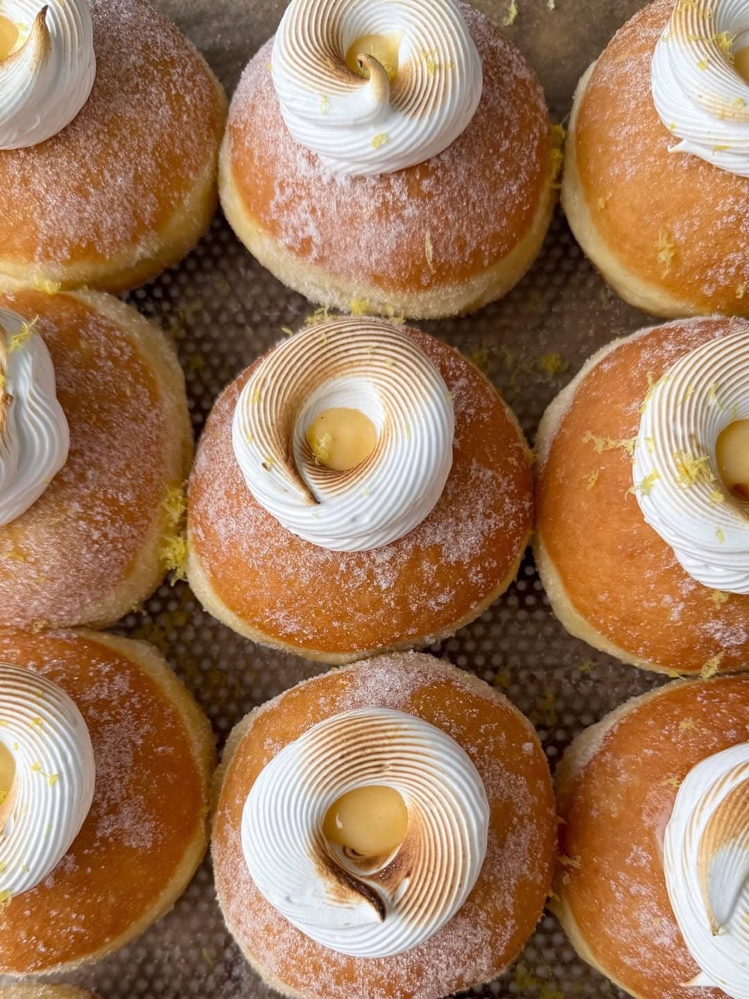 Tray of lemon meringue sugar donuts with toasted meringue swirl and lemon curd at Flour Bakery Caringbah South Sydney World Donut Day