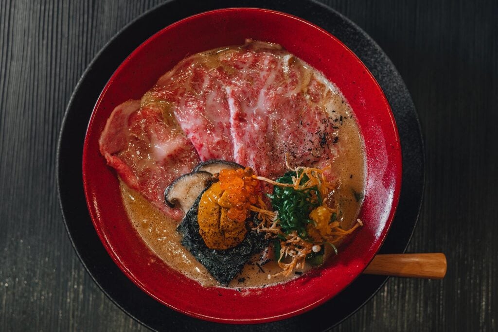 Mensho Tokyo Ramen wagyu beef ramen with uni ikura and nori in creamy broth red bowl Sydney CBD