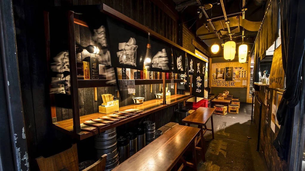 Nakano Darling izakaya narrow timber bar interior with Japanese banner walls and paper lanterns Darling Square Haymarket Sydney