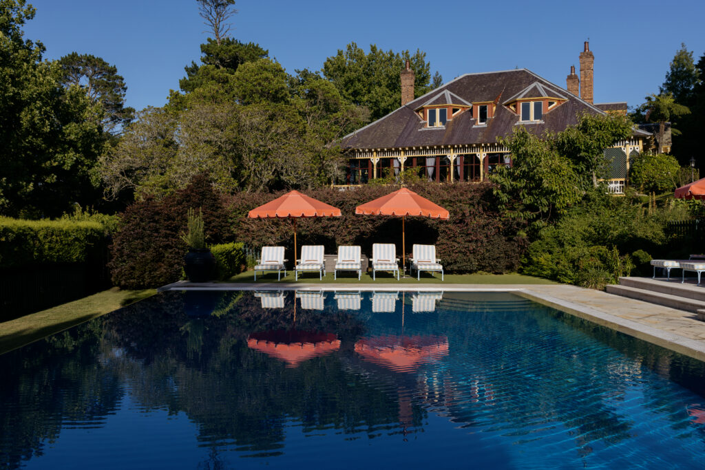 Outdoor pool with orange umbrellas and sun loungers at Ardour Lilianfels Katoomba Blue Mountains