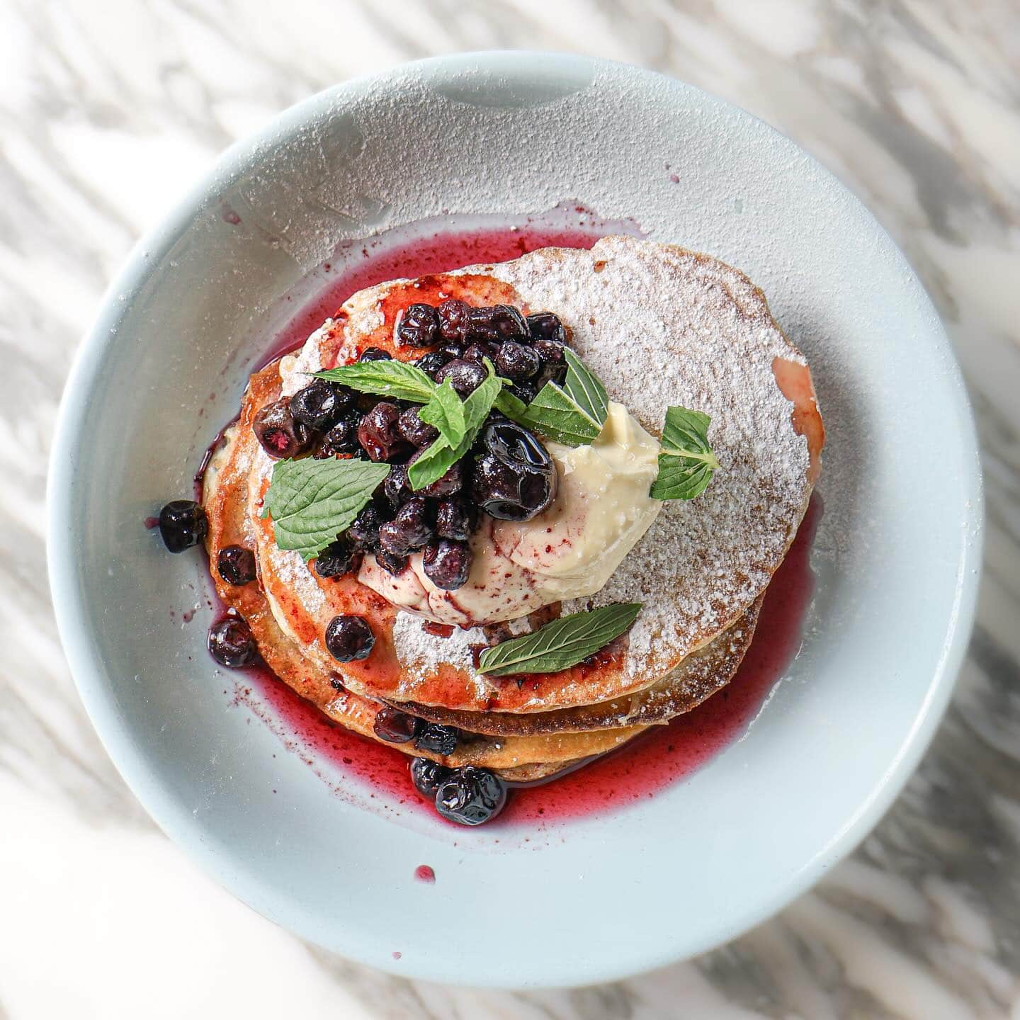 A stack of pancakes doused in berries at The Boathouse Balmoral Beach.