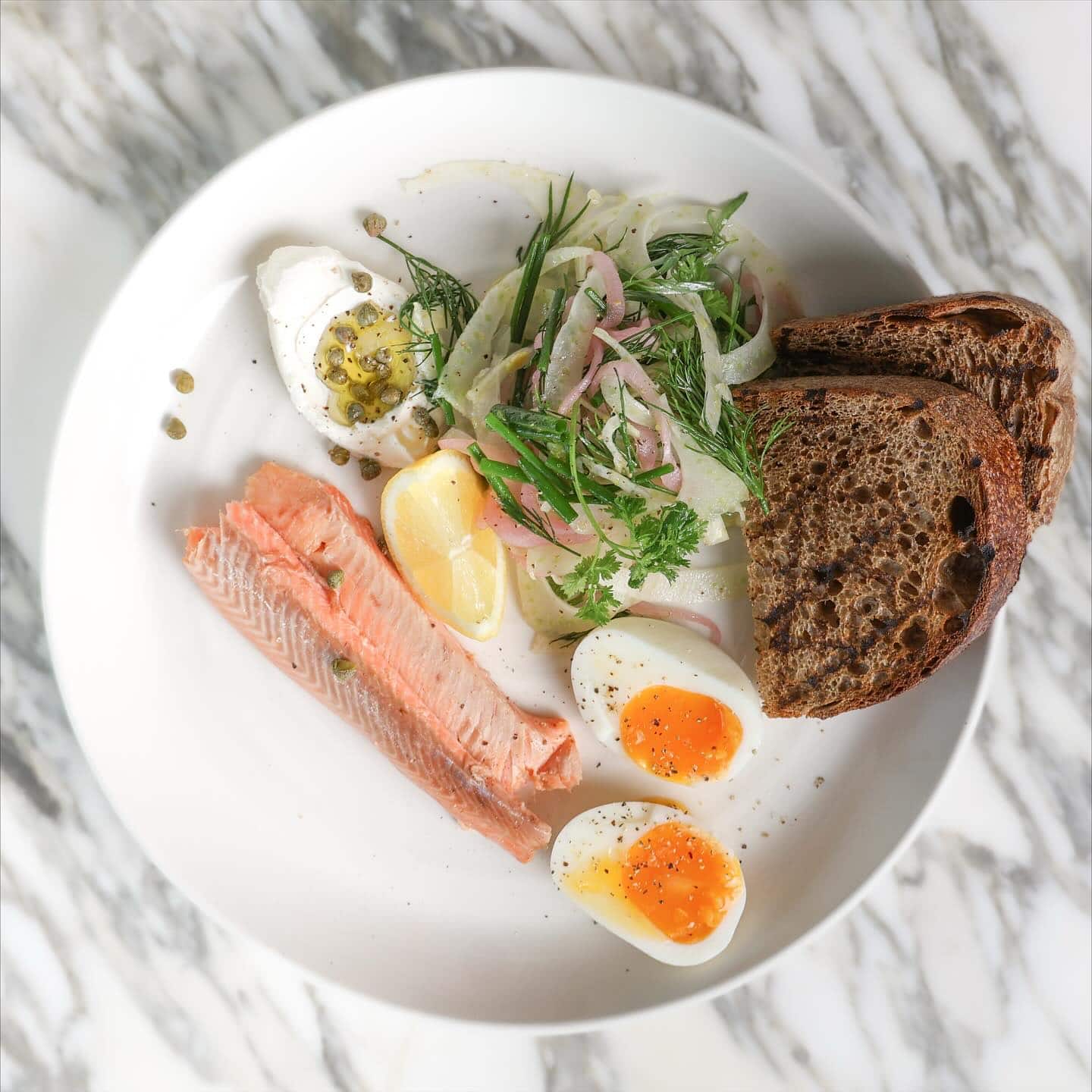 A breakfast plate, complete with boiled eggs, salmon and toast at The Boathouse Balmoral Beach.