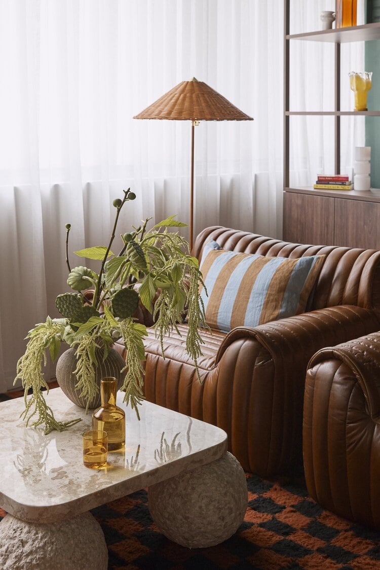 Salon HER lounge area with tan leather sofa marble coffee table and rattan floor lamp Darlinghurst Sydney