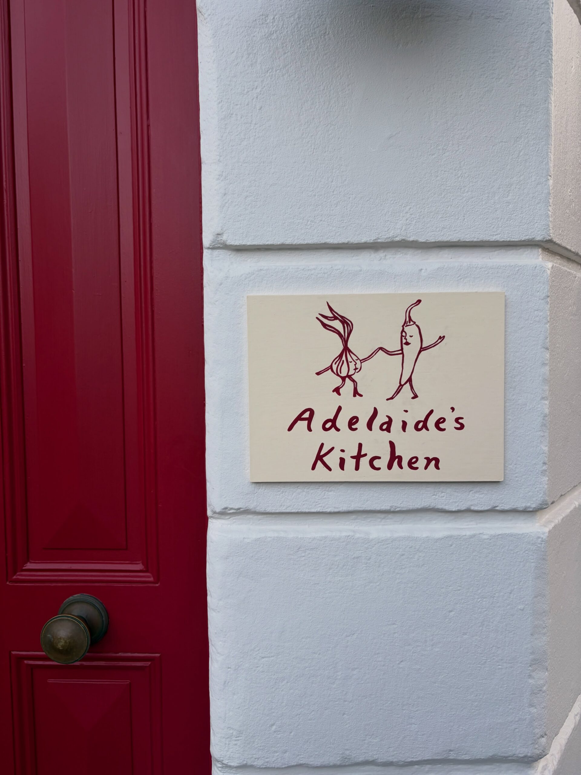 Adelaide's Kitchen shopfront signage beside red door Paddington Sydney