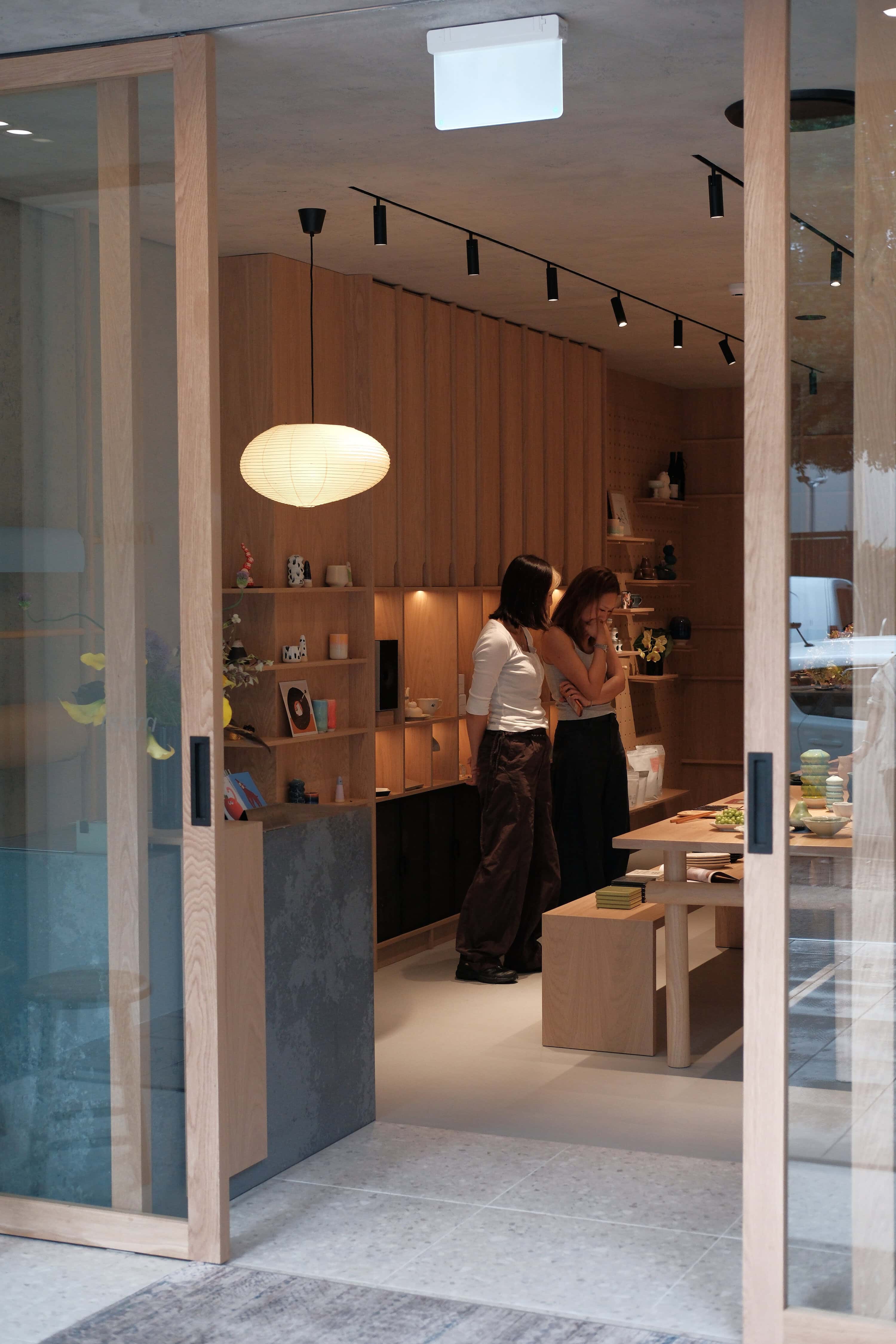Store interior entrance with timber shelving and pendant lighting at Noom Rosebery Sydney