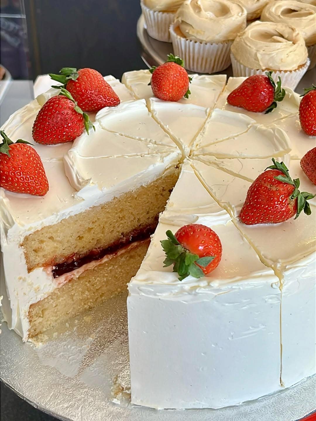A large double-layered strawberry chiffon cake with a slice taken out, from Fink's Clissold House