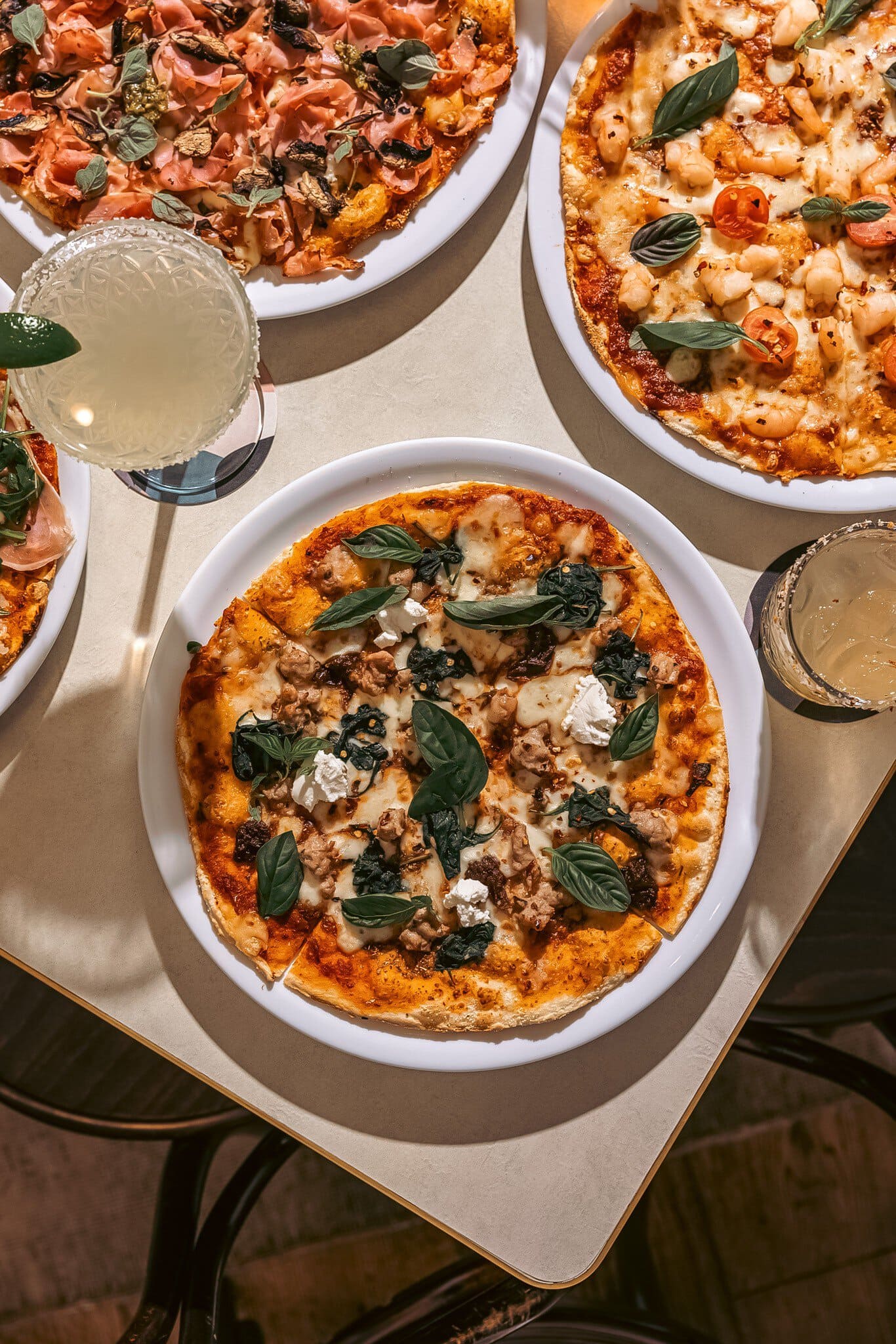 The Oaks Hotel three pizzas on table with sausage feta prosciutto and prawn toppings with cocktails Neutral Bay Sydney